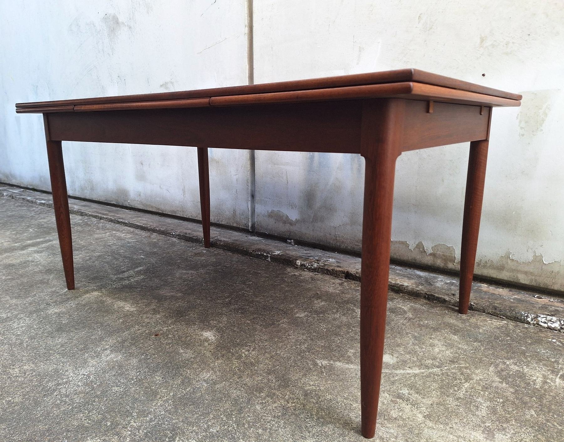 Side profile showing the tapered legs and extension leaves beneath the tabletop.