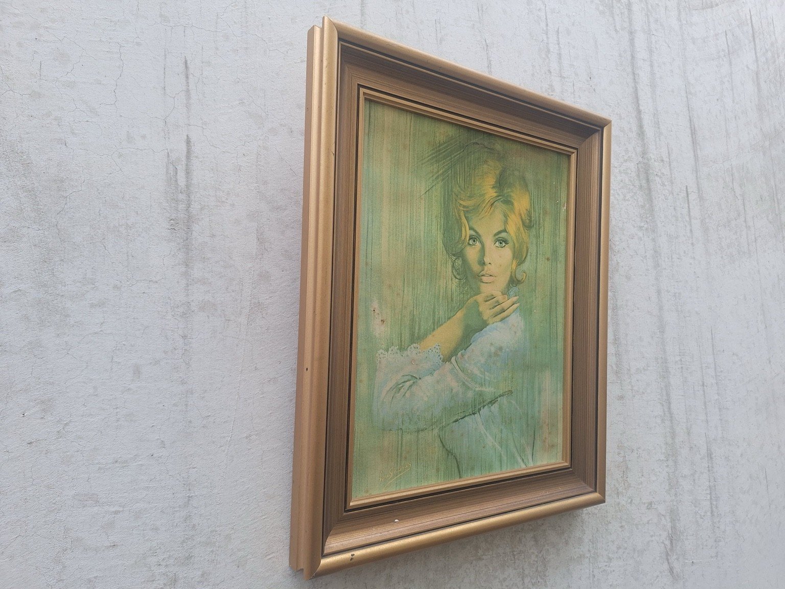 Opposite angled view of the framed portrait showing frame scuffs and chips.