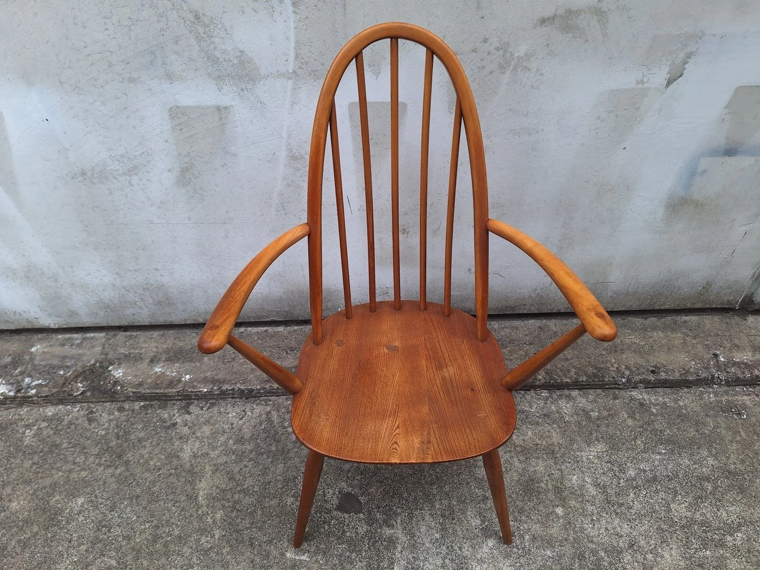 Elevated front view of the Ercol carver chair showing the shaped seat and curved armrests.