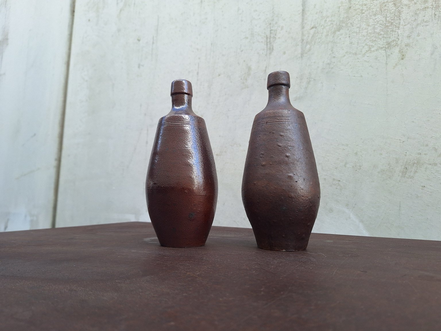Full view of both Portuguese ceramic vases against the original studio wall.