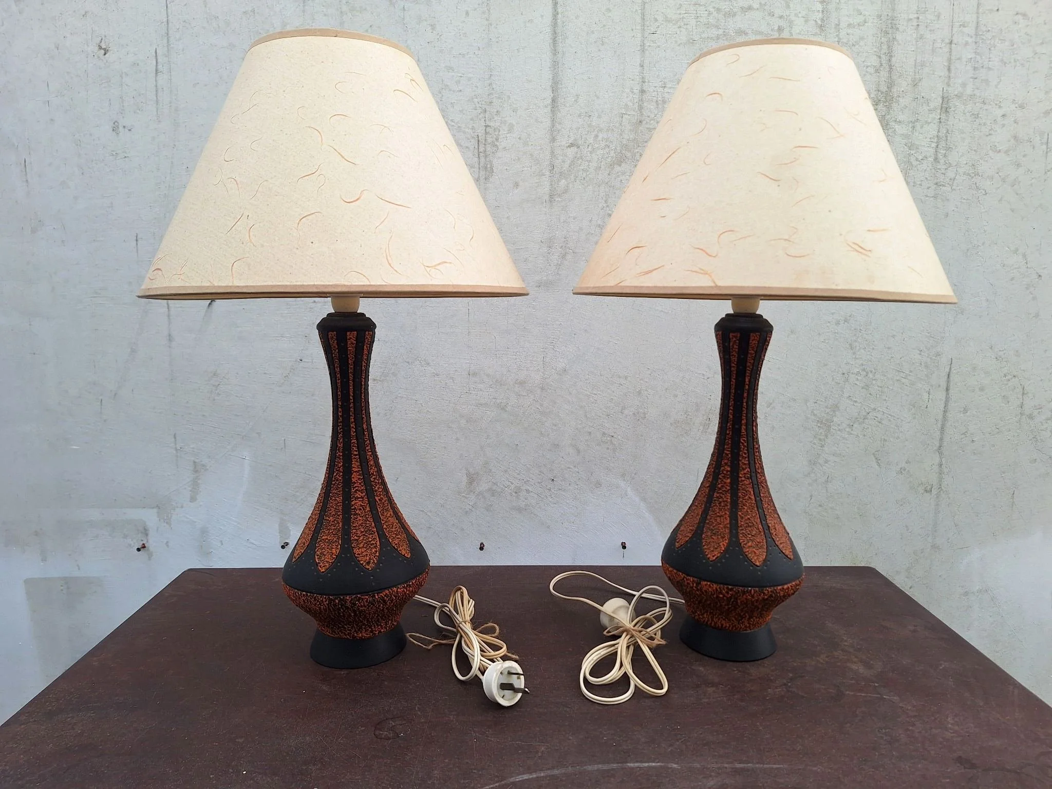 Detail of textured plaster lamp base with orange and black finish.