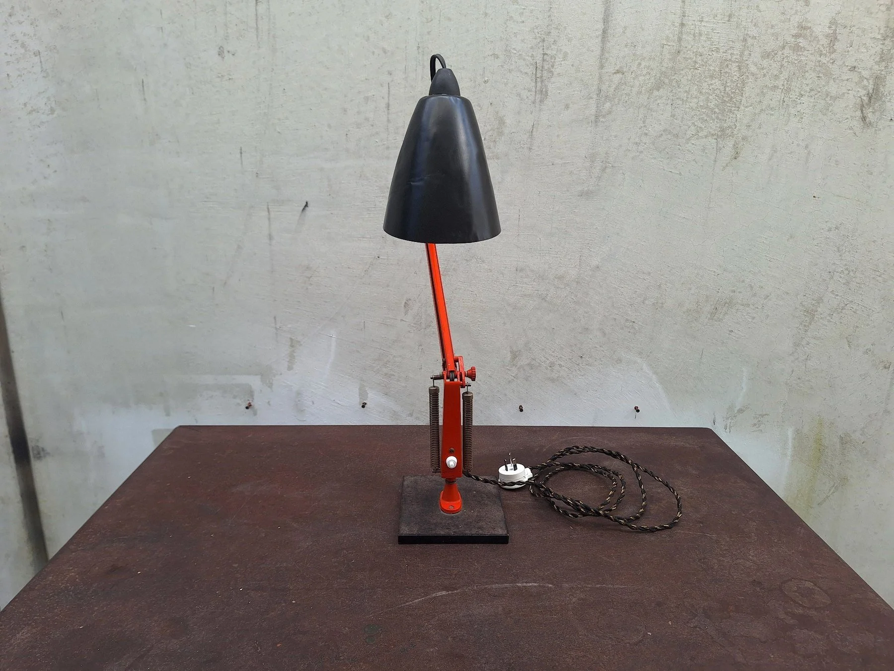 Vintage Planet Studio desk lamp with orange articulated arm, black metal shade and original Planet Products maker's label on weighted base.