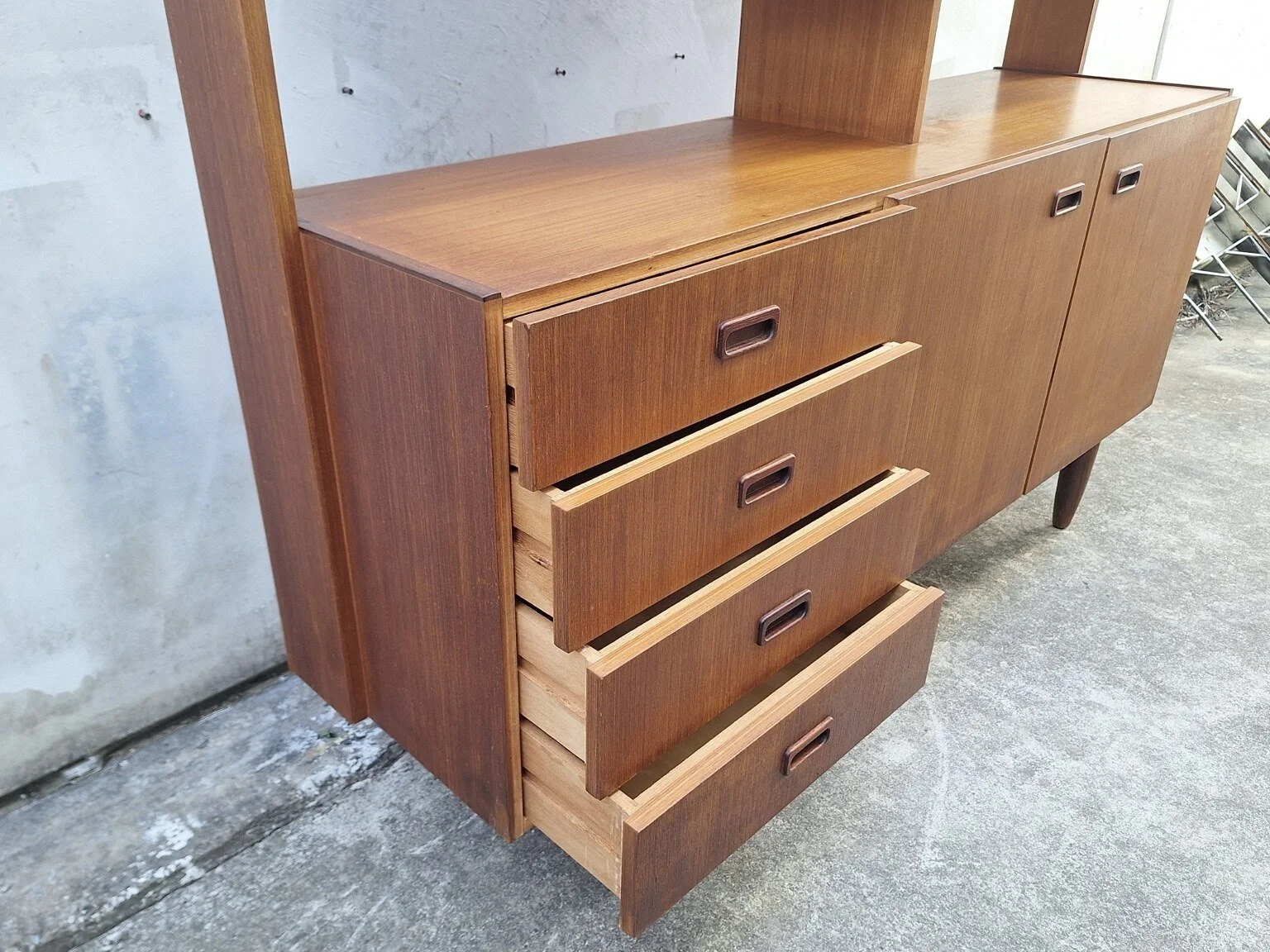 Four open drawers on the left side of the vintage timber-veneer wall unit