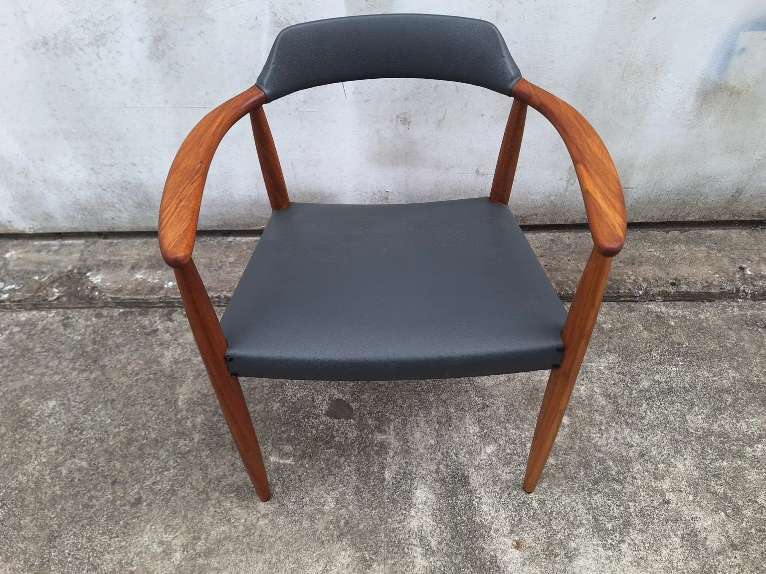 Front view of the armchair showing the curved arms and seat.