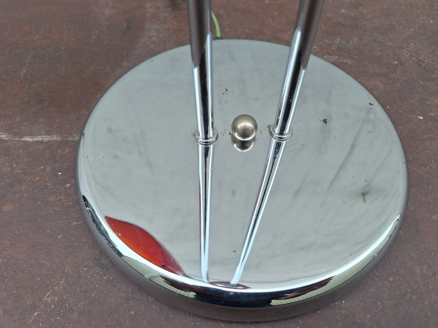 Chrome lamp base showing surface marks, pitting and the central control.