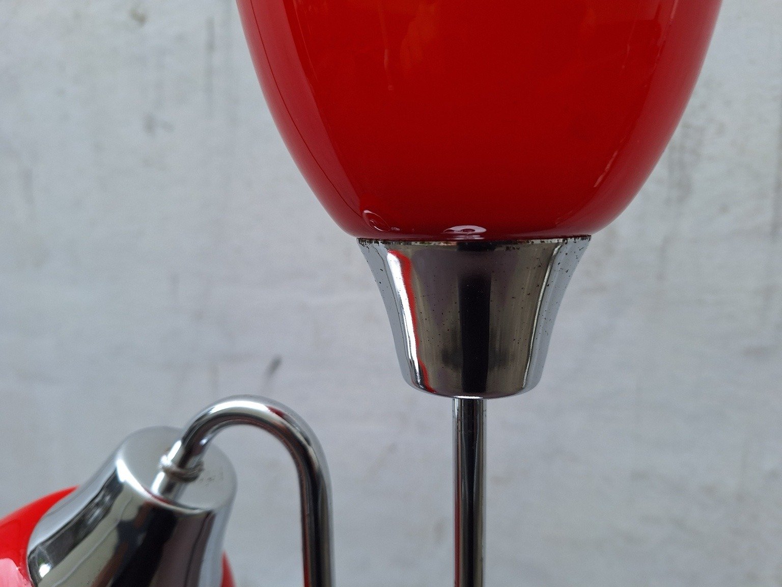Close view of pitting and wear on the chrome fitting beneath the upper red shade.