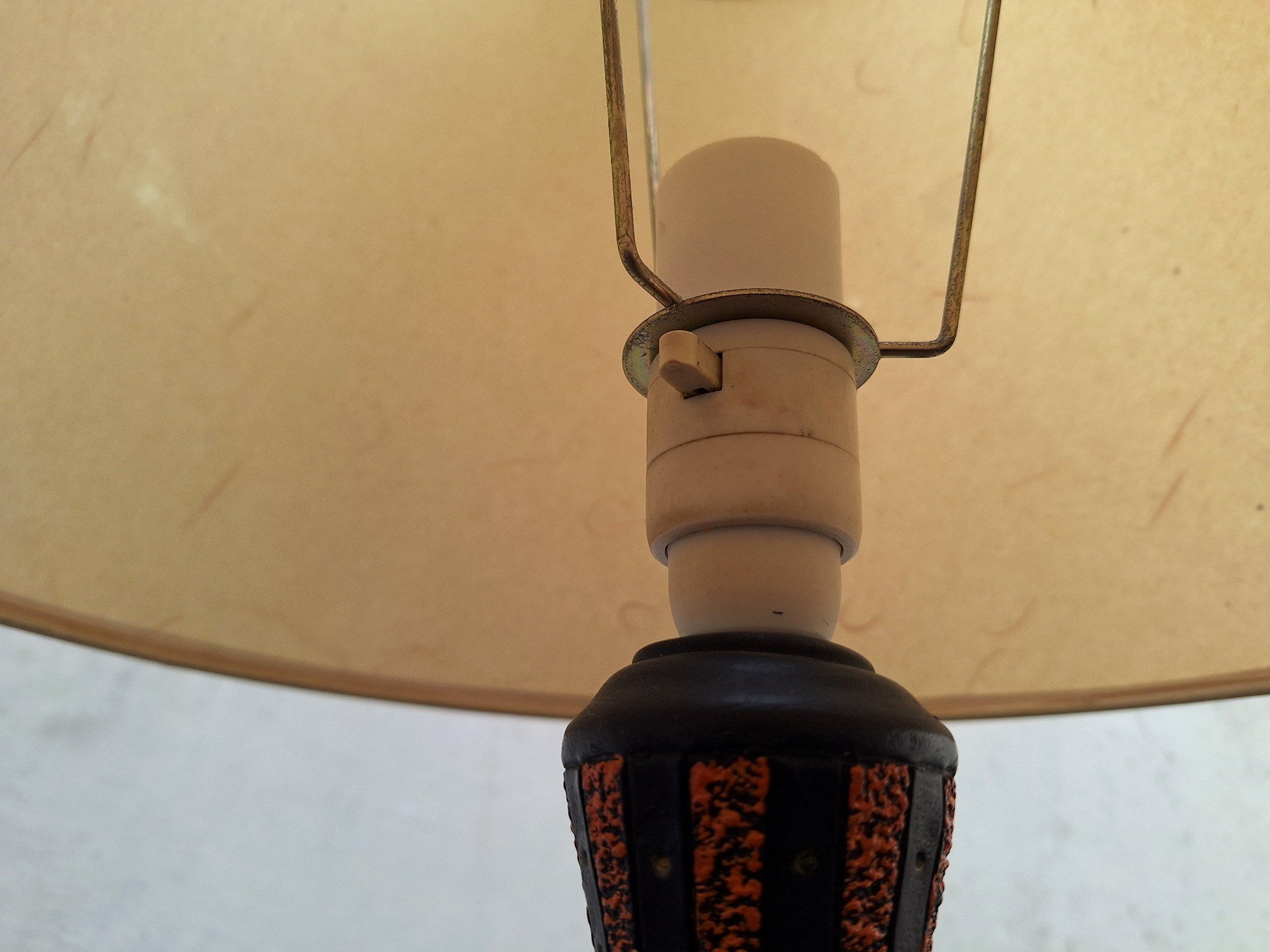 Detail of textured plaster lamp base with orange and black finish.