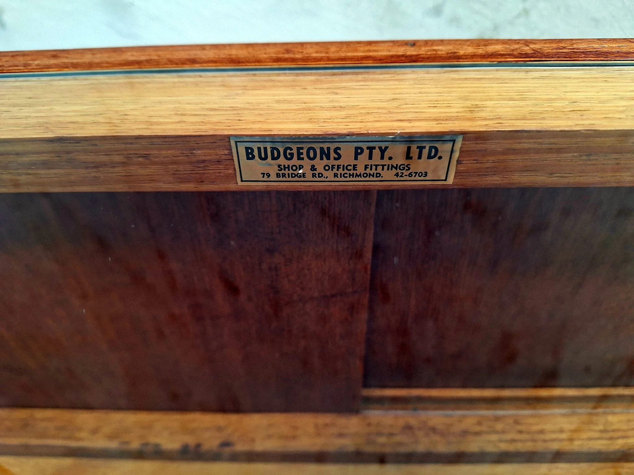 mid-century glass display cabinet maker label