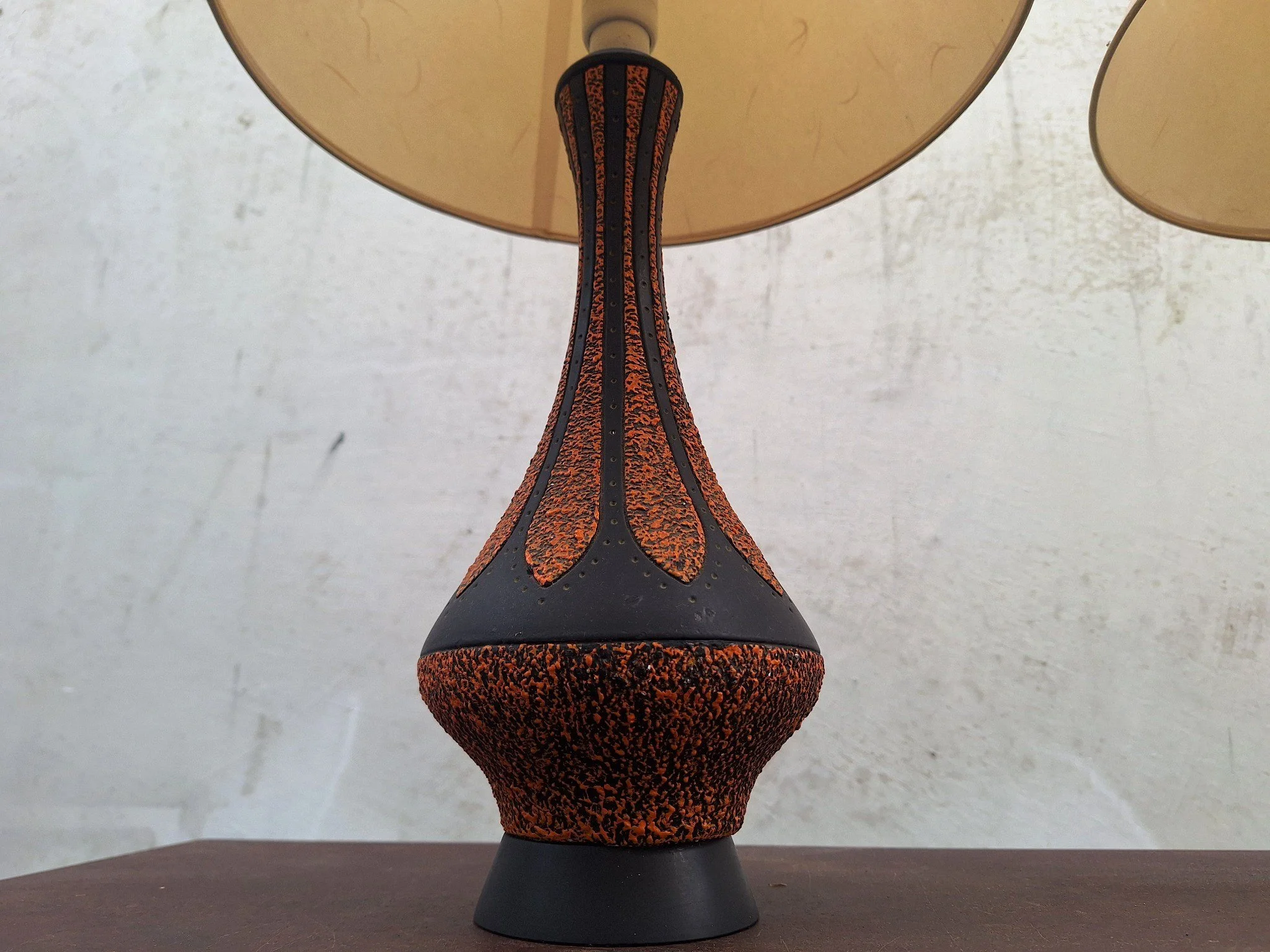 Detail of textured plaster lamp base with orange and black finish.