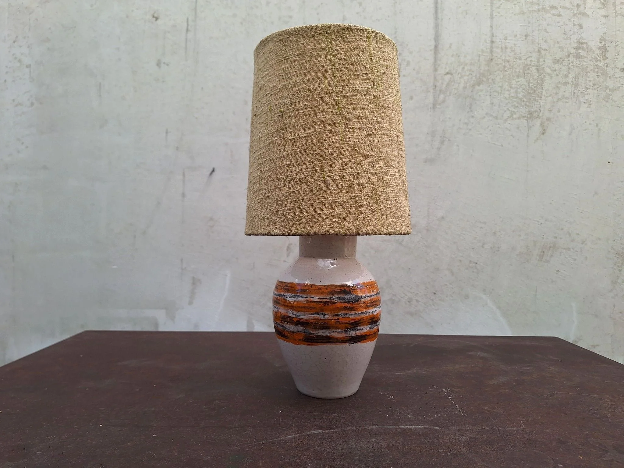 Vintage Bitossi ceramic table lamp with textured off white glaze, orange and charcoal banding, woven shade and braided cord.