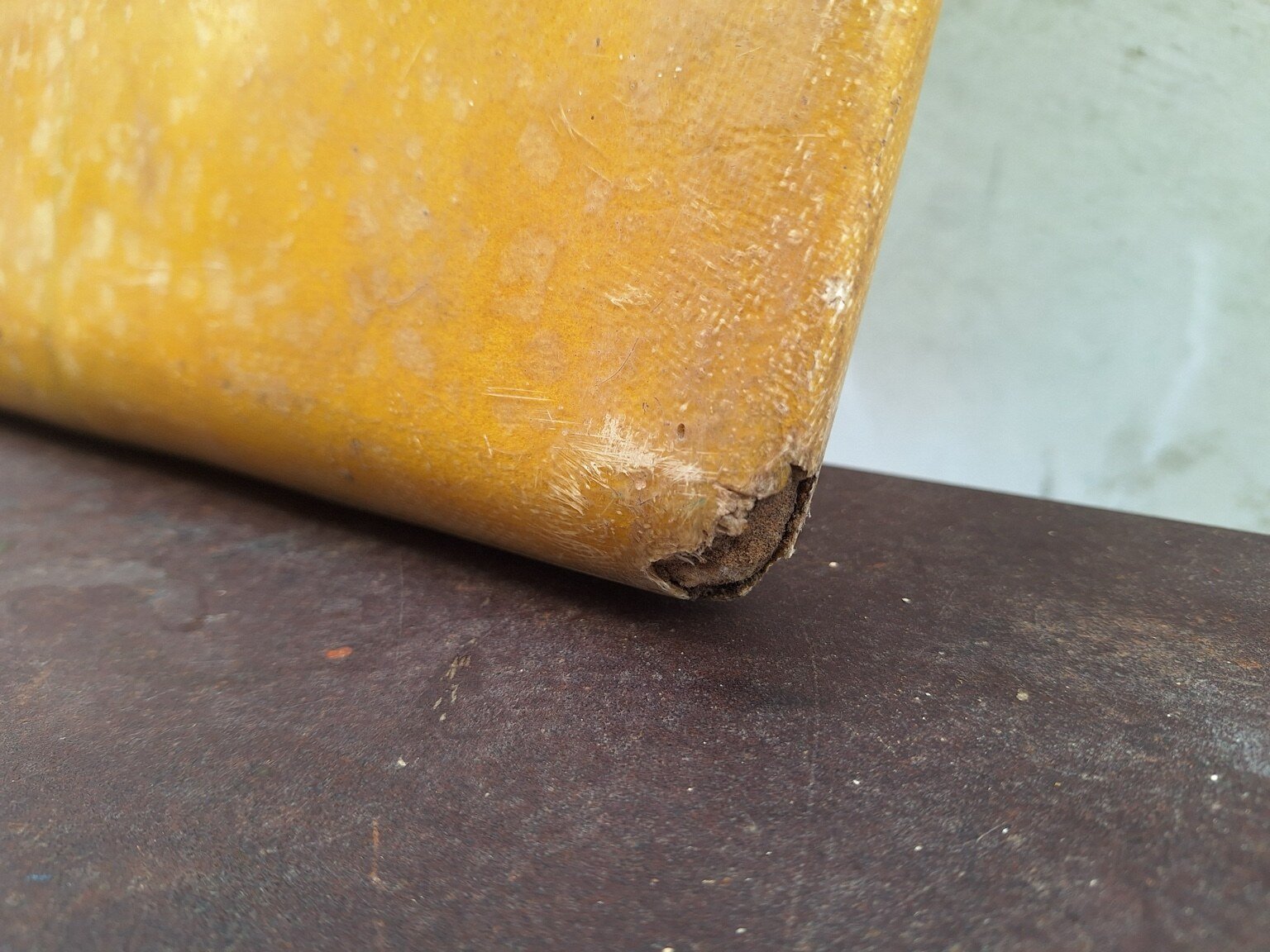 Close view of wear and damage at the right corner of the surfboard’s square tail.