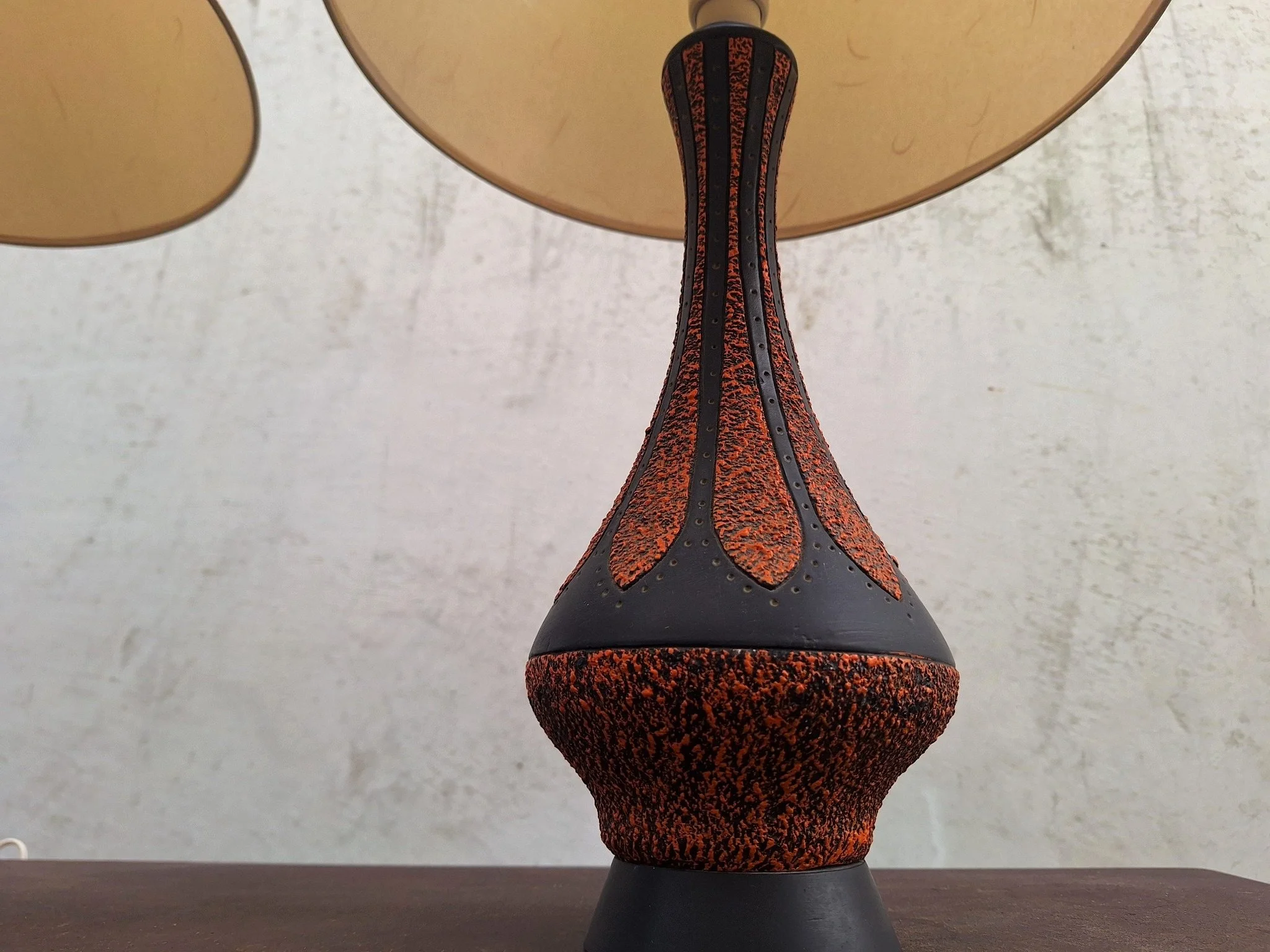 Detail of textured plaster lamp base with orange and black finish.