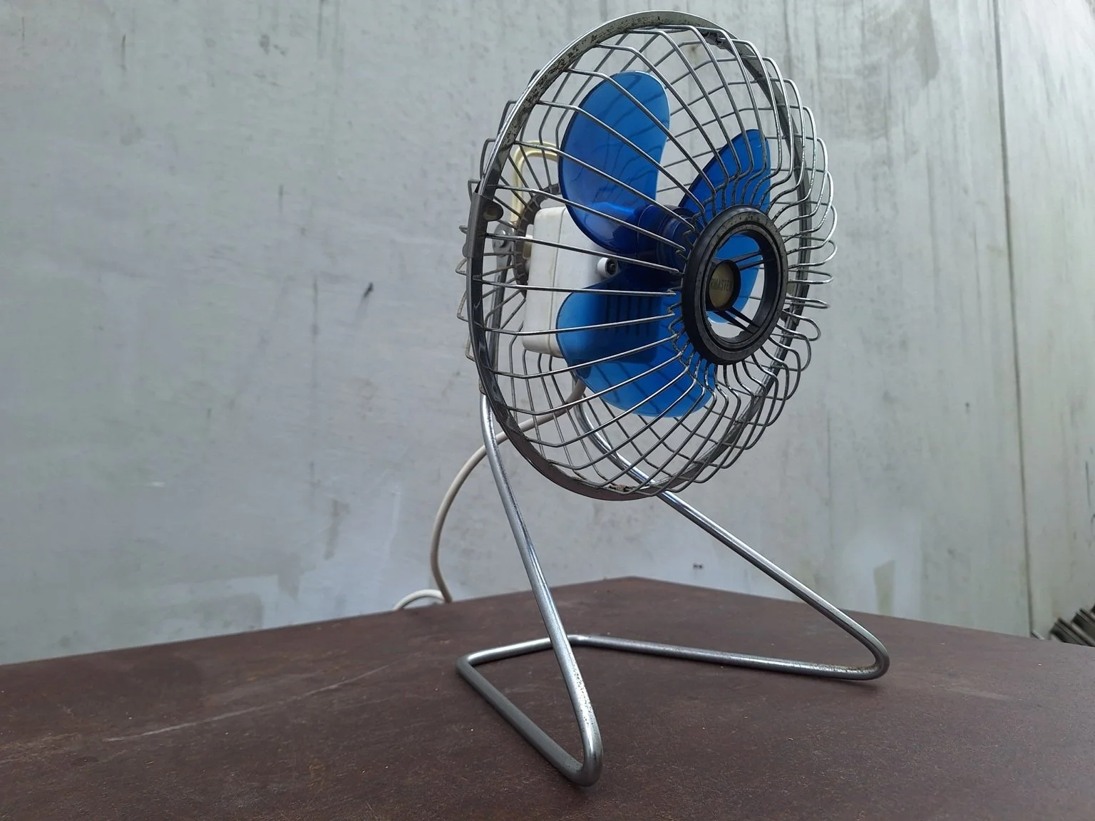 Side view of the adjustable Airmaster desk fan showing the motor housing and stand.