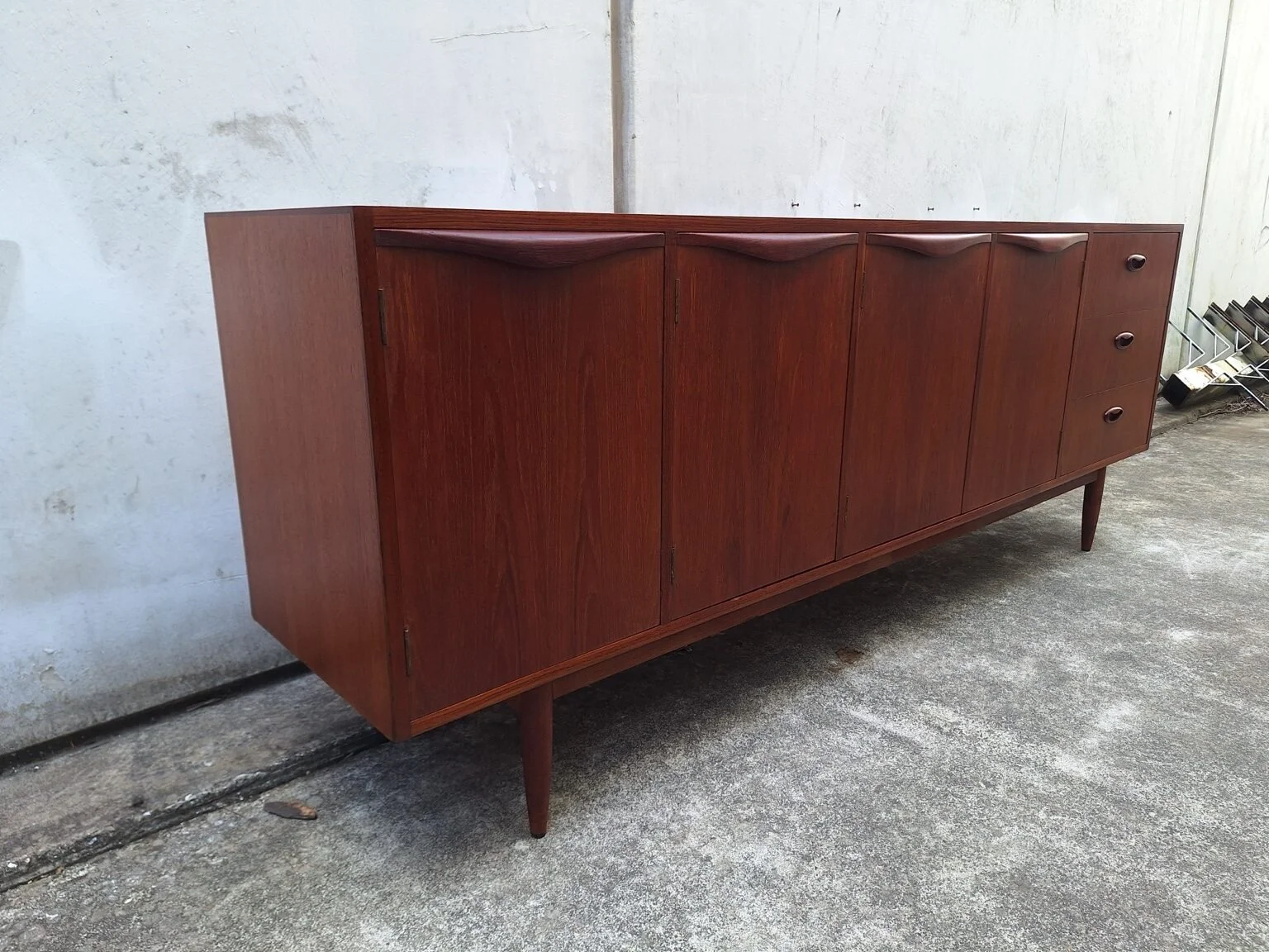 Left three-quarter view showing the long, low profile and sculpted door handles of the Chiswell sideboard.