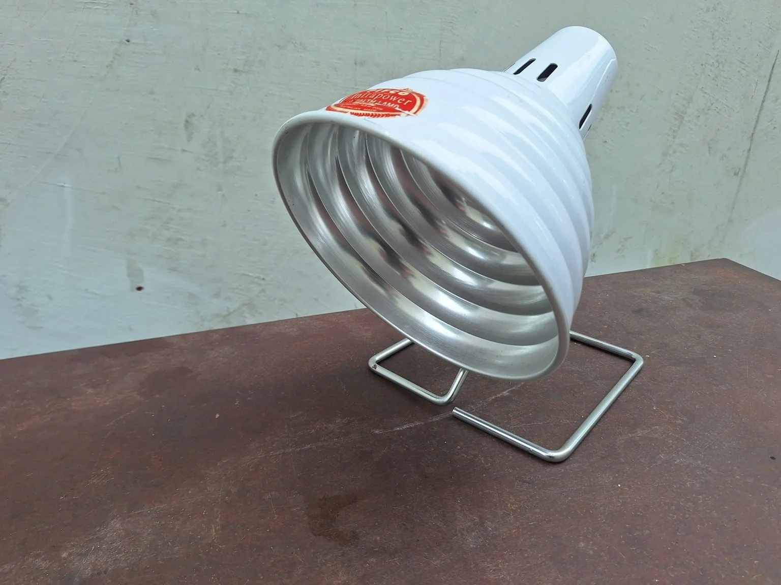 Three-quarter view of white Pifco Infrapower lamp with ribbed shade and wire stand.