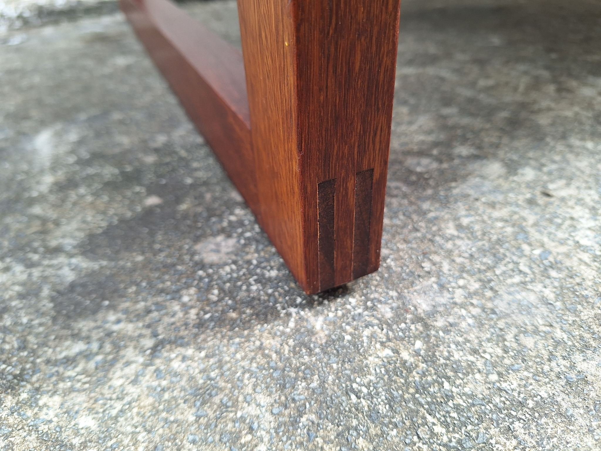 Restored mid century modern teak coffee table with architectural frame and rich teak grain.
