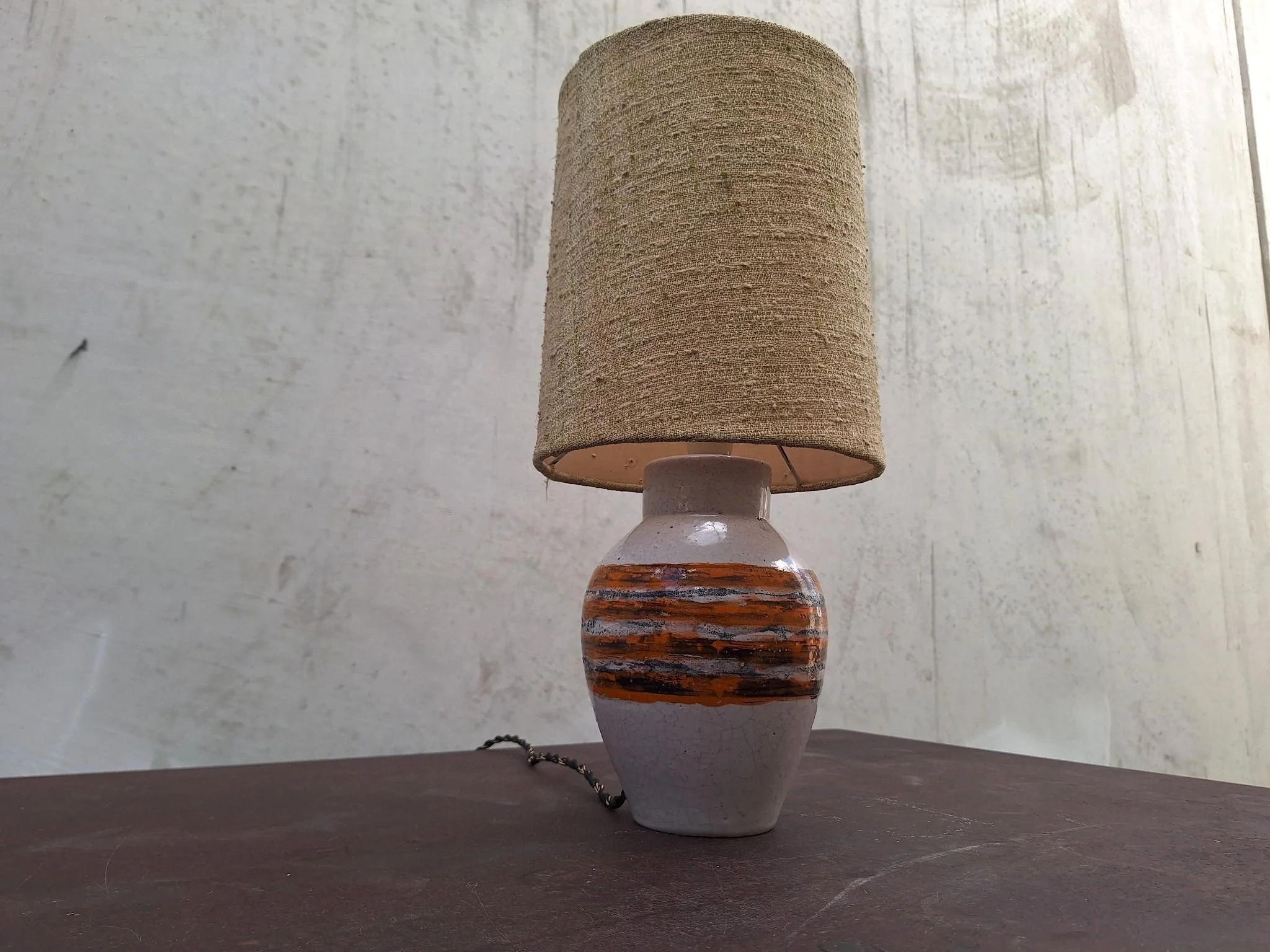 Vintage Bitossi ceramic table lamp with textured off white glaze, orange and charcoal banding, woven shade and braided cord.