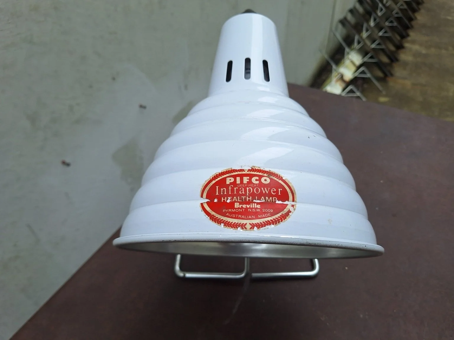 Worn red Pifco Infrapower Breville Australian-made label on white shade.