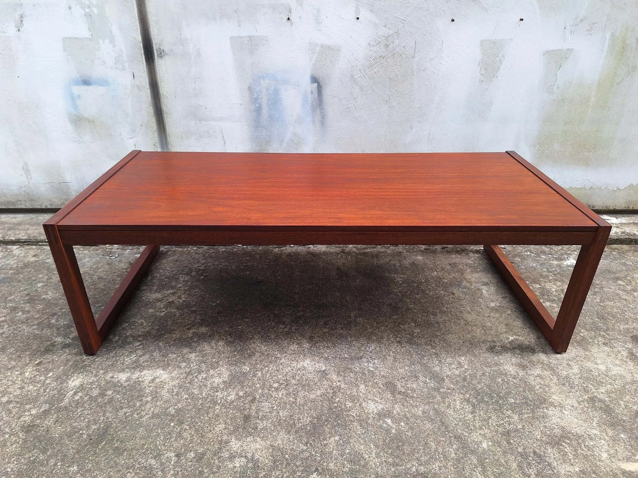 Restored mid century modern teak coffee table with architectural frame and rich teak grain.