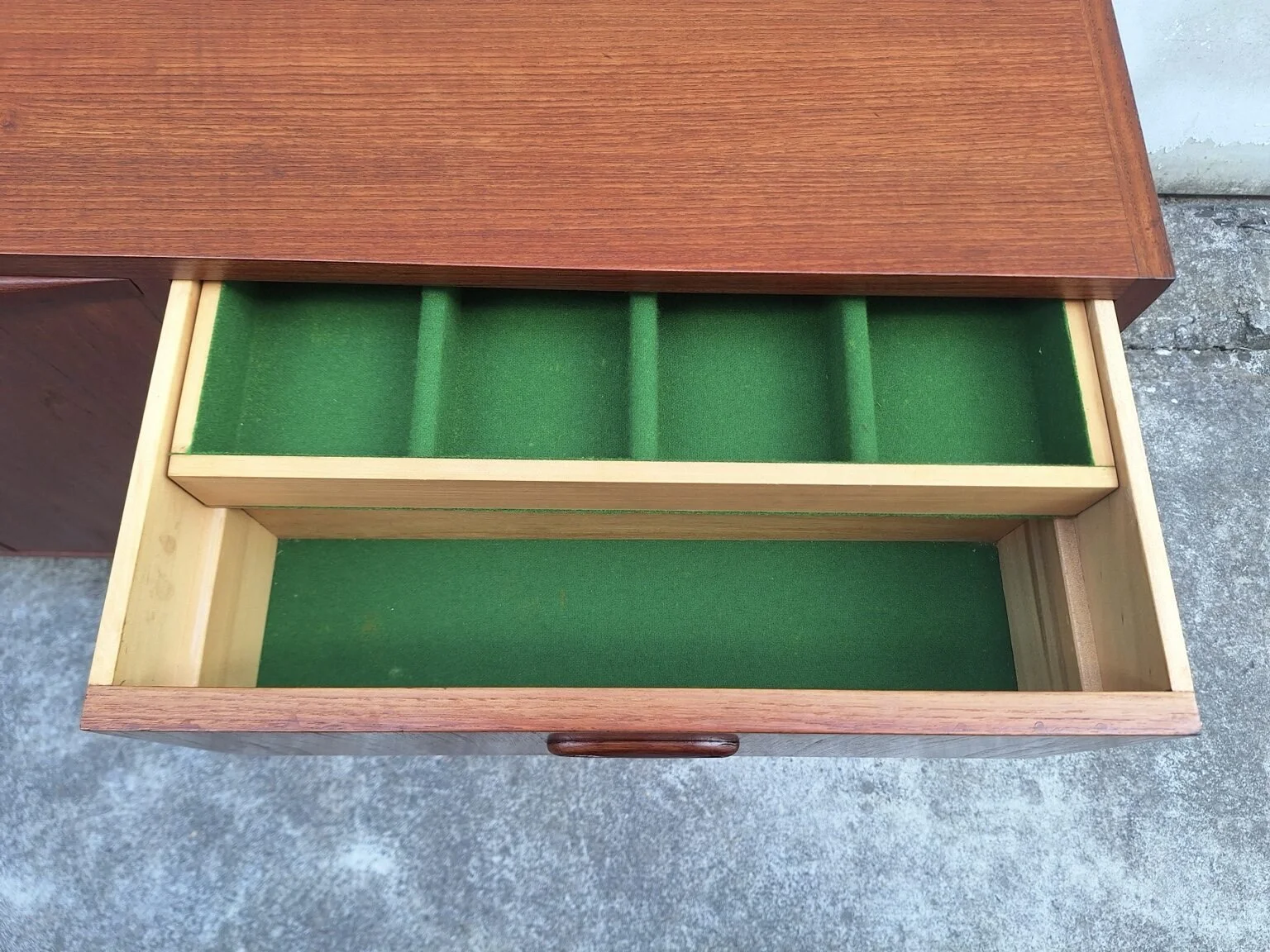 Open top drawer showing the green felt-lined cutlery tray inside the Chiswell sideboard.