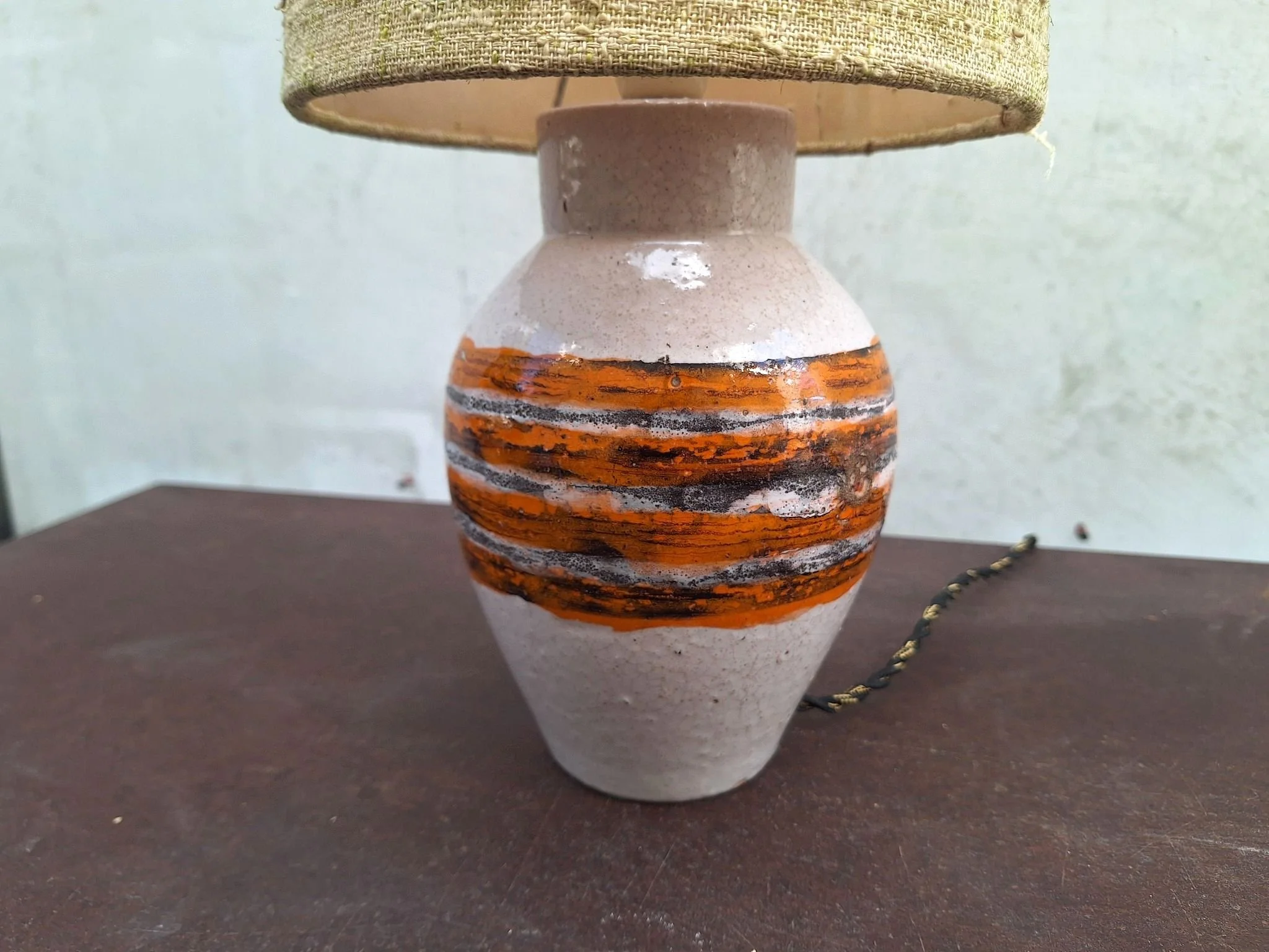 Vintage Bitossi ceramic table lamp with textured off white glaze, orange and charcoal banding, woven shade and braided cord.