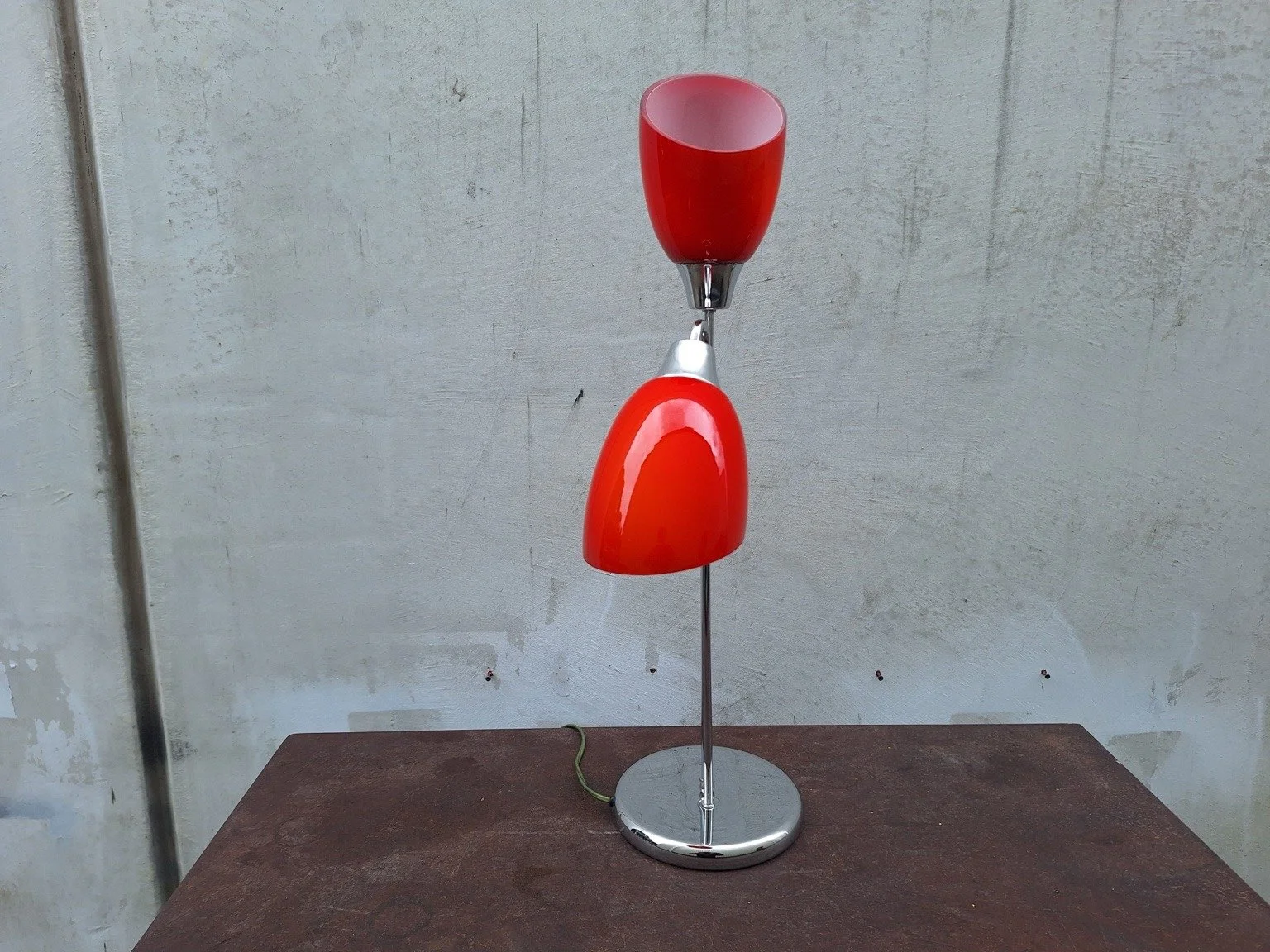 Reverse view showing the open upper red shade and circular chrome base.
