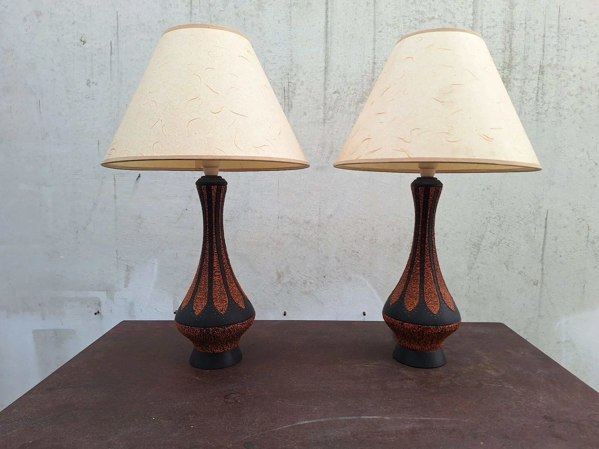 Detail of textured plaster lamp base with orange and black finish.