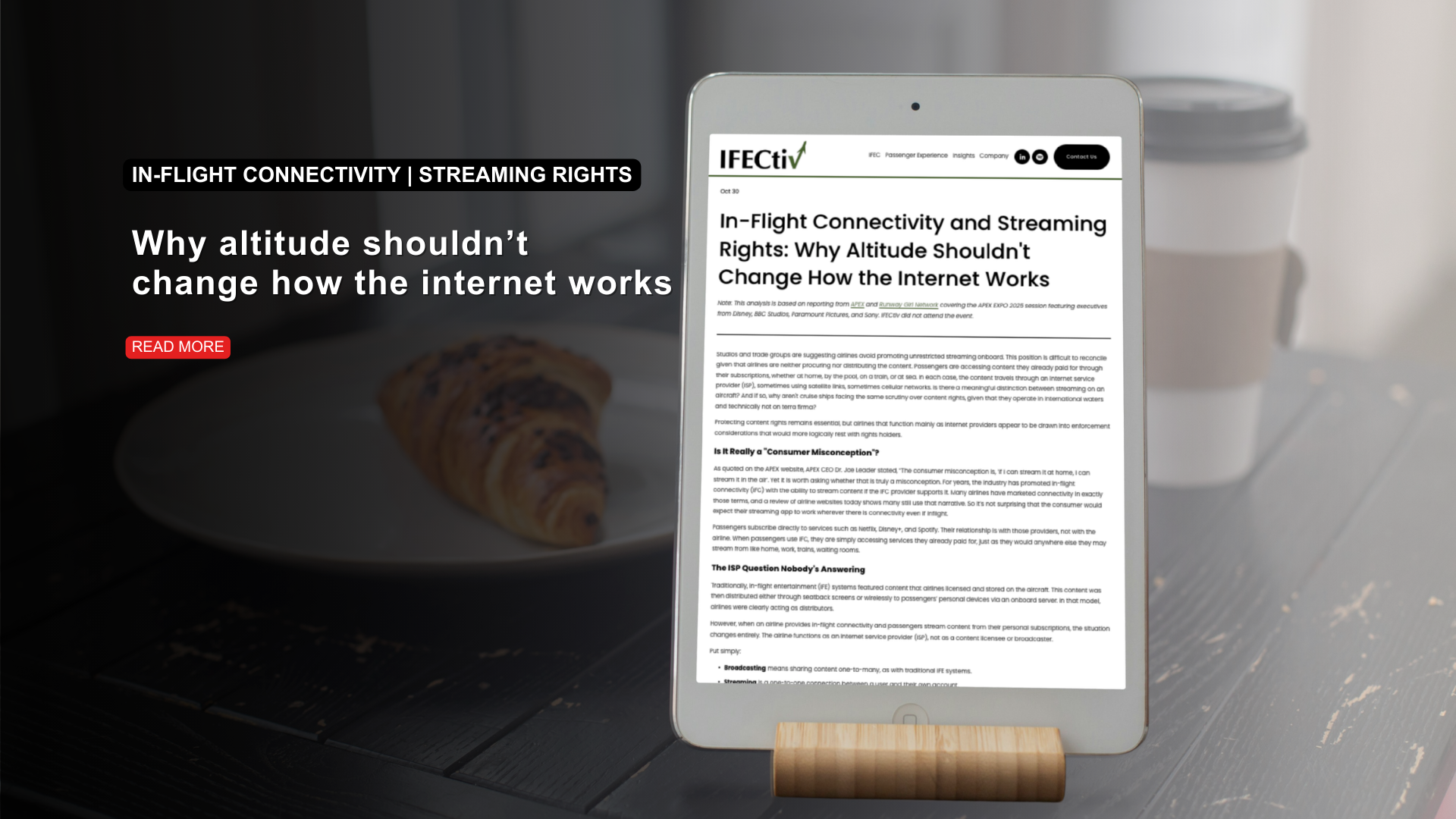 A digital tablet displaying an article titled "In-flight Connectivity and Streaming Rights: Why Altitude Shouldn't Change How the Internet Works" on a wooden stand, with a headline on the left reading "In-flight connectivity and streaming rights: Why