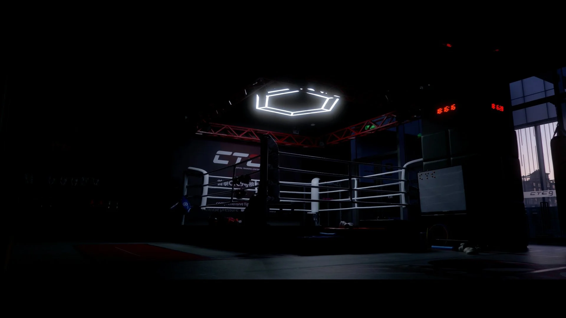 An empty boxing ring inside a modern gym, with dim lighting and a digital clock displaying 18:16:16 in red, and large windows showing a cityscape outside.