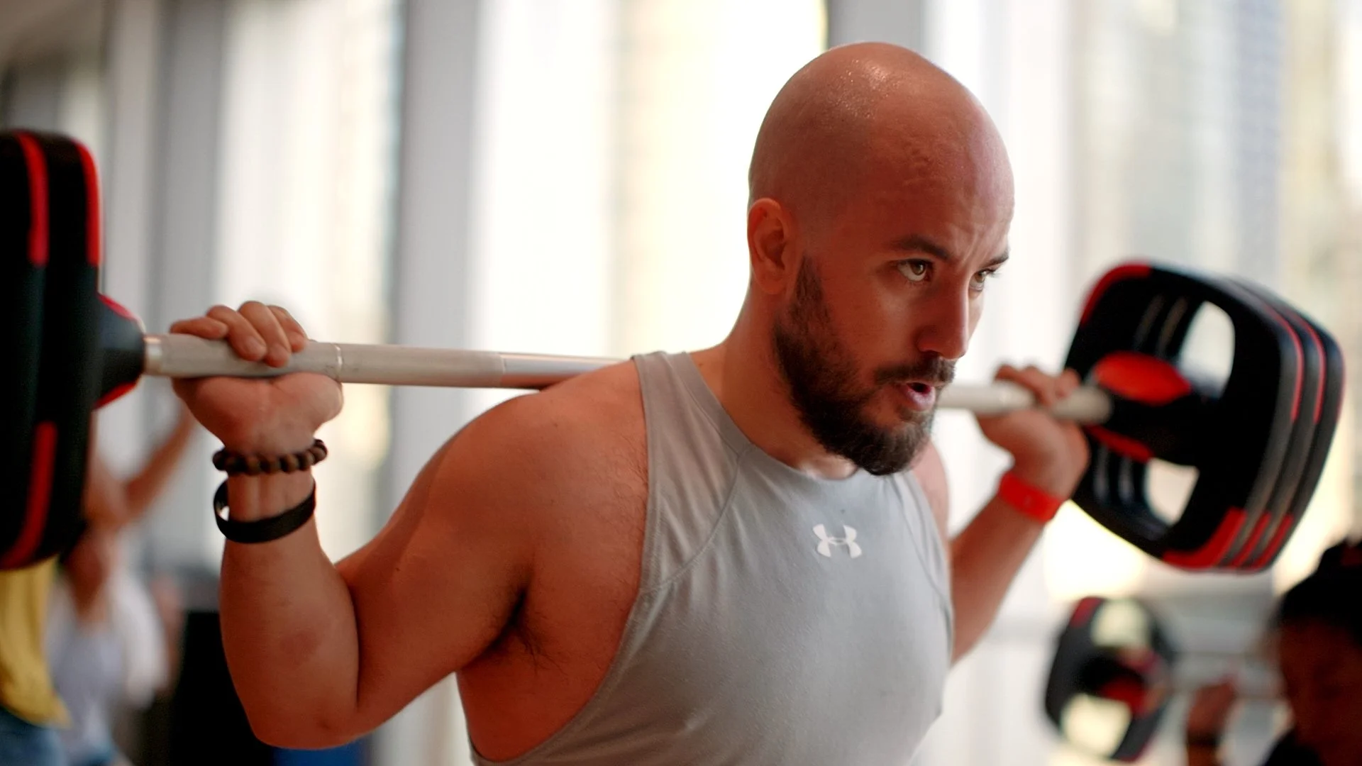 Man lifting a barbell during a workout at the gym.