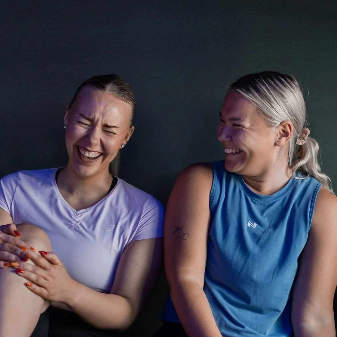 Kaksi naista nauravat ja juttelevat keskenään