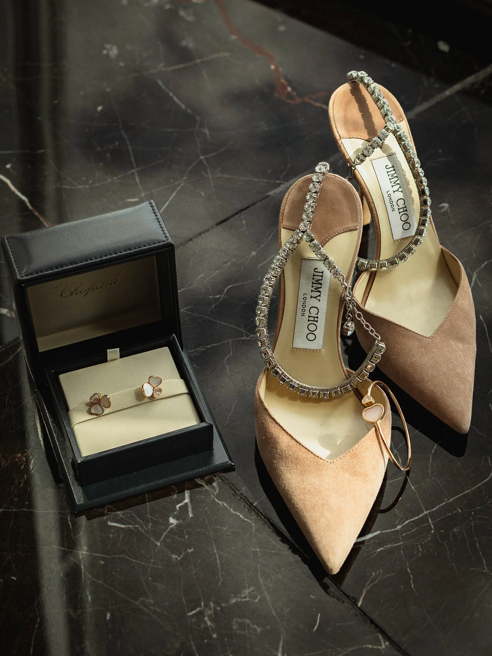 Exquisite and luxurious bridal details on the morning of a London wedding, showing the brides earrings, bracelet and Jimmy Choo shoes.