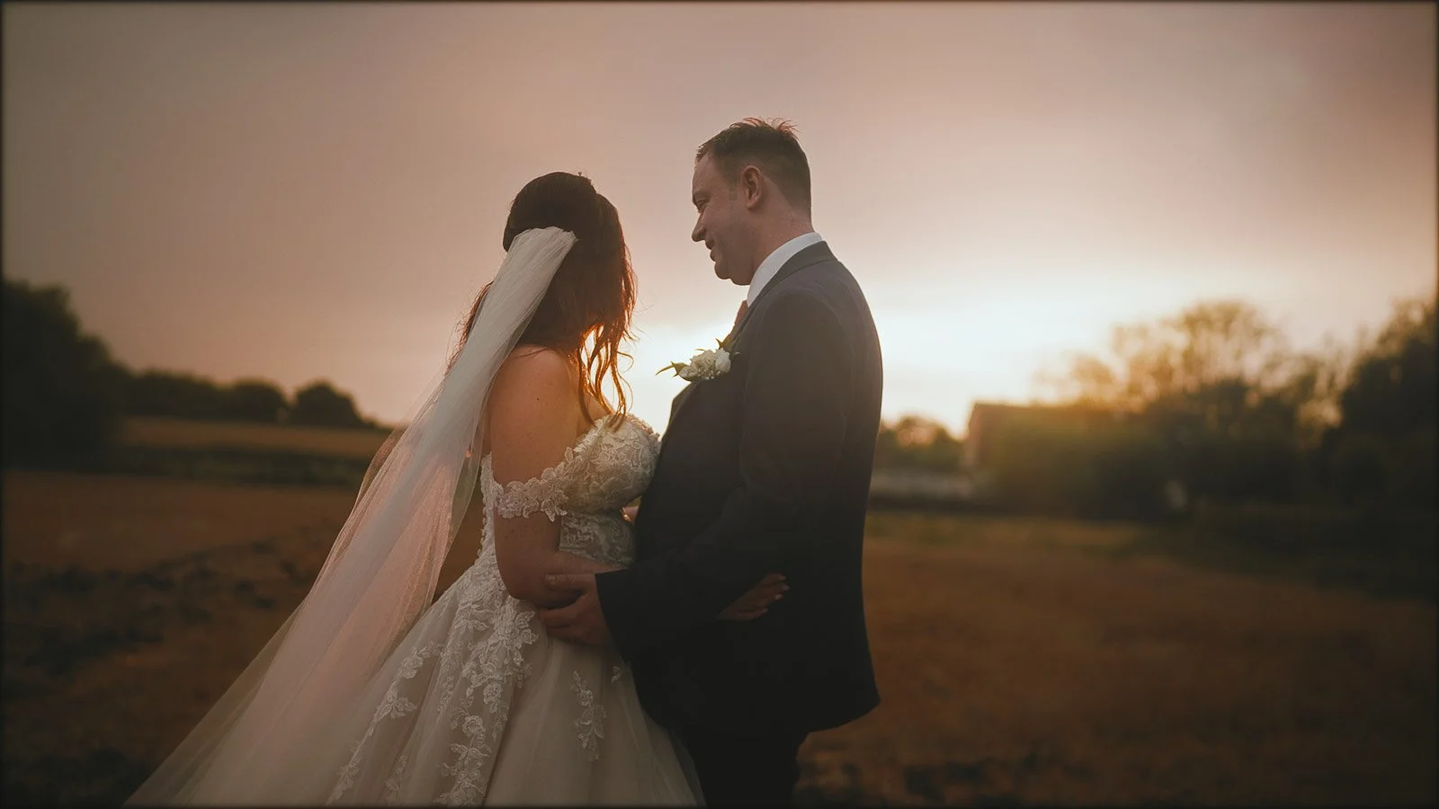 Romantic couple moment captured during a Cooling Castle Barn sunset session as the groom looks at the bride.