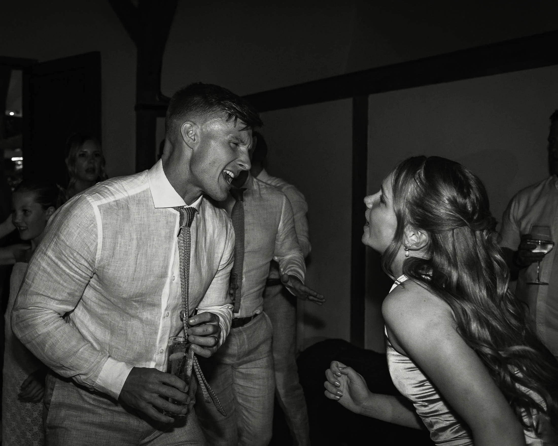 A candid high-energy black and white wedding photograph of evening celebrations and dancing at Winters Barns in Kent.