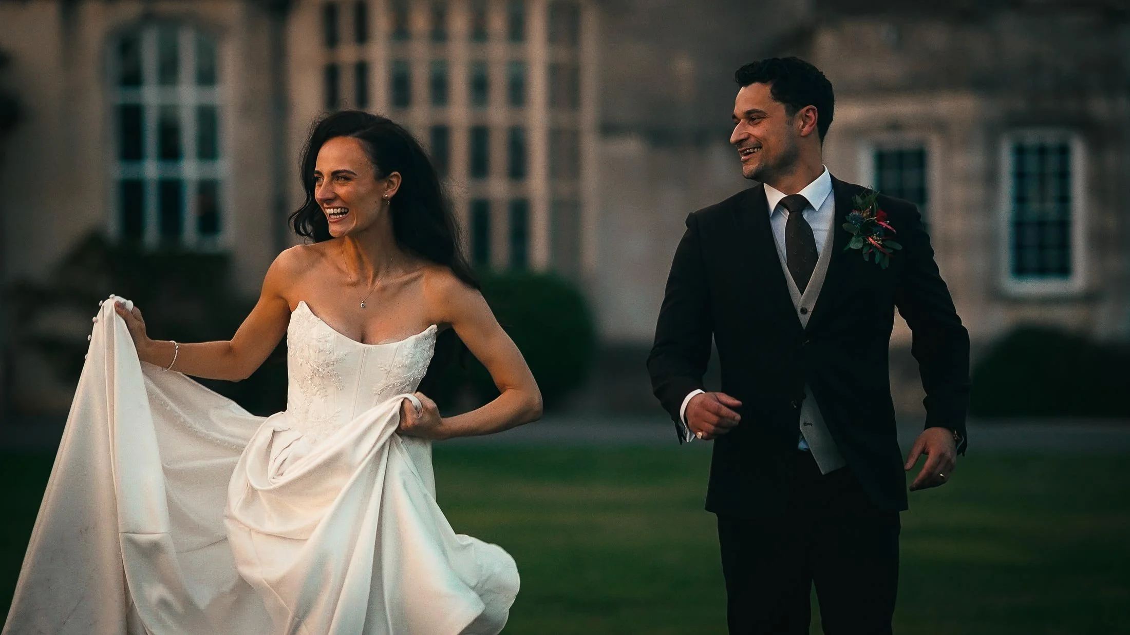 Bride and Groom run through the grounds of Elmore Court during sunset.