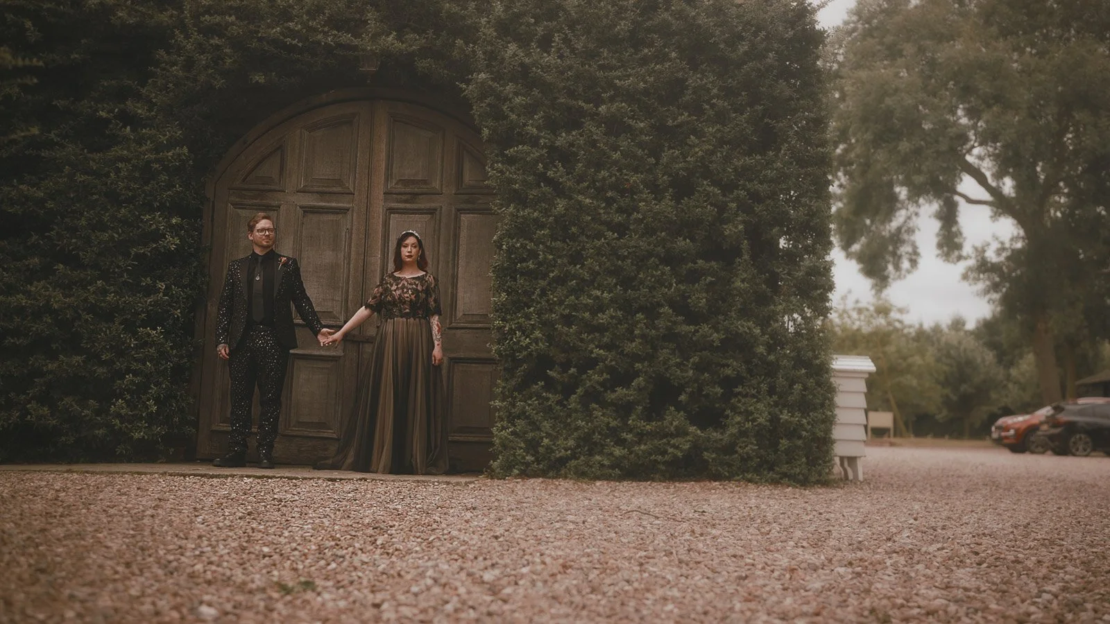 An editorial pose by a couple during portraits at golden hour in a Winters Barns wedding film, as they stand by the famous old barn doors on their alternative wedding day.