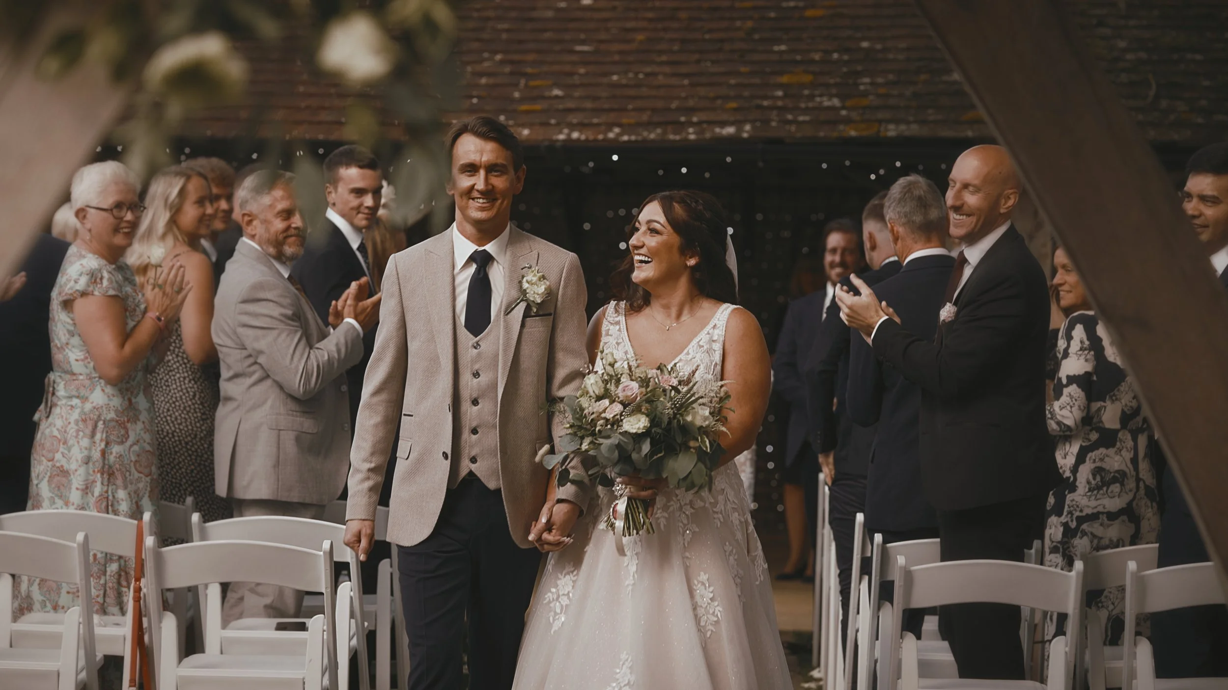A fun moment in a Winters Barns wedding video as the couple exit their outdoor ceremony together.