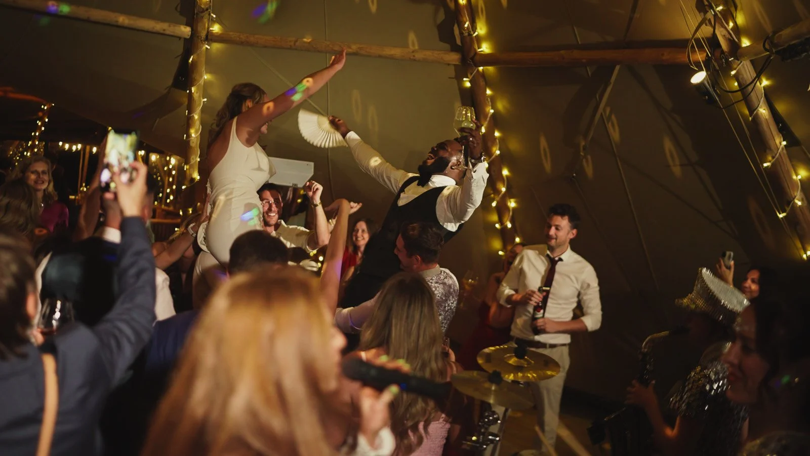 Editorial-style wedding photography from a colourful riverside celebration with bold florals and a marquee reception.