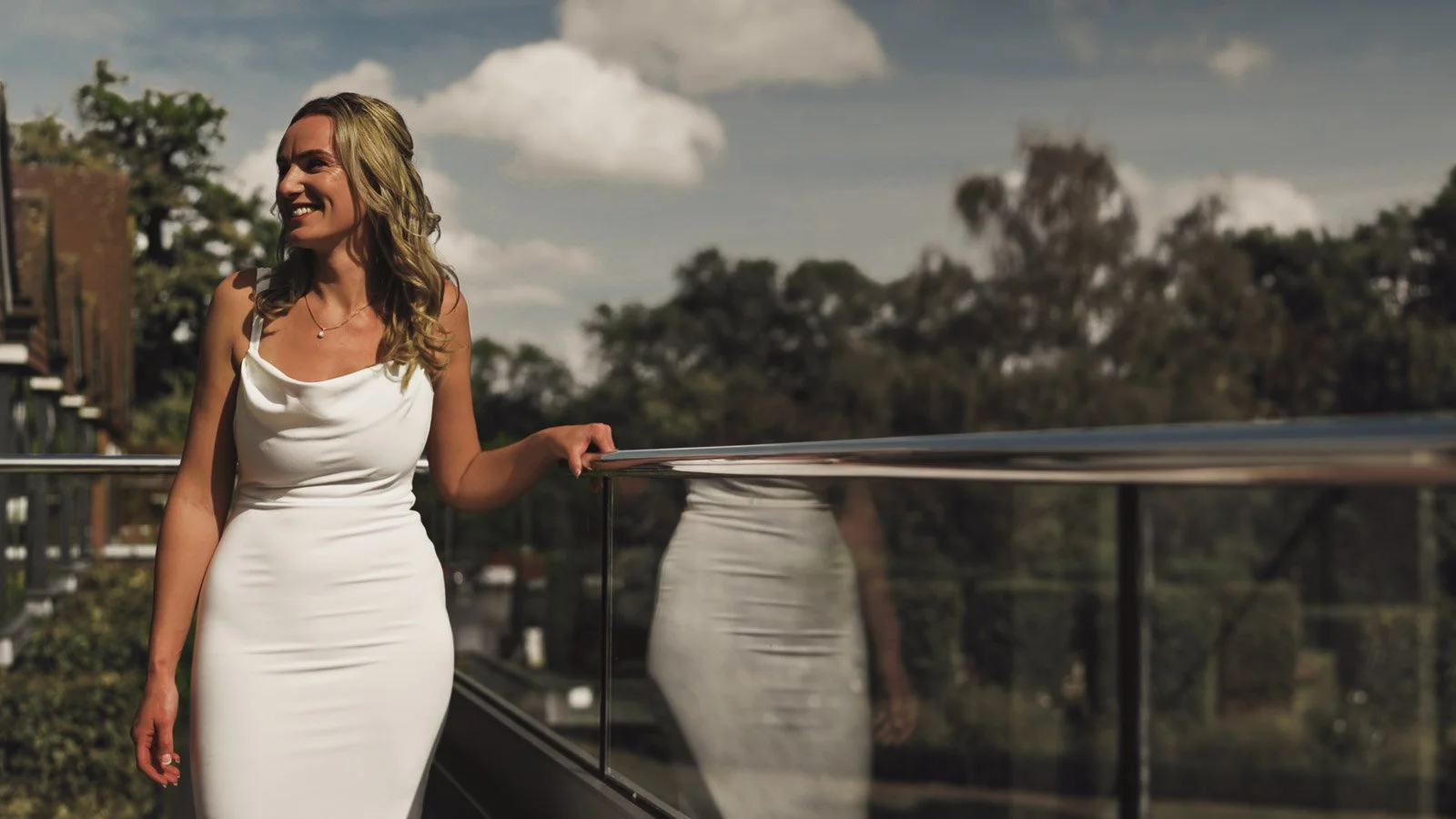 A portrait of a bride wearing an elegant luxury dress, taken in an Oxfordshire Estate garden during a colourful riverside wedding day.