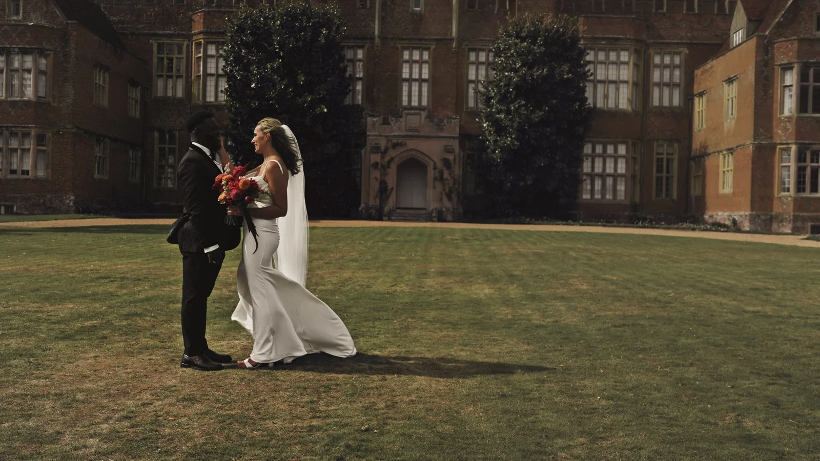 Editorial-style wedding photography from a colourful riverside celebration with bold florals and a marquee reception.