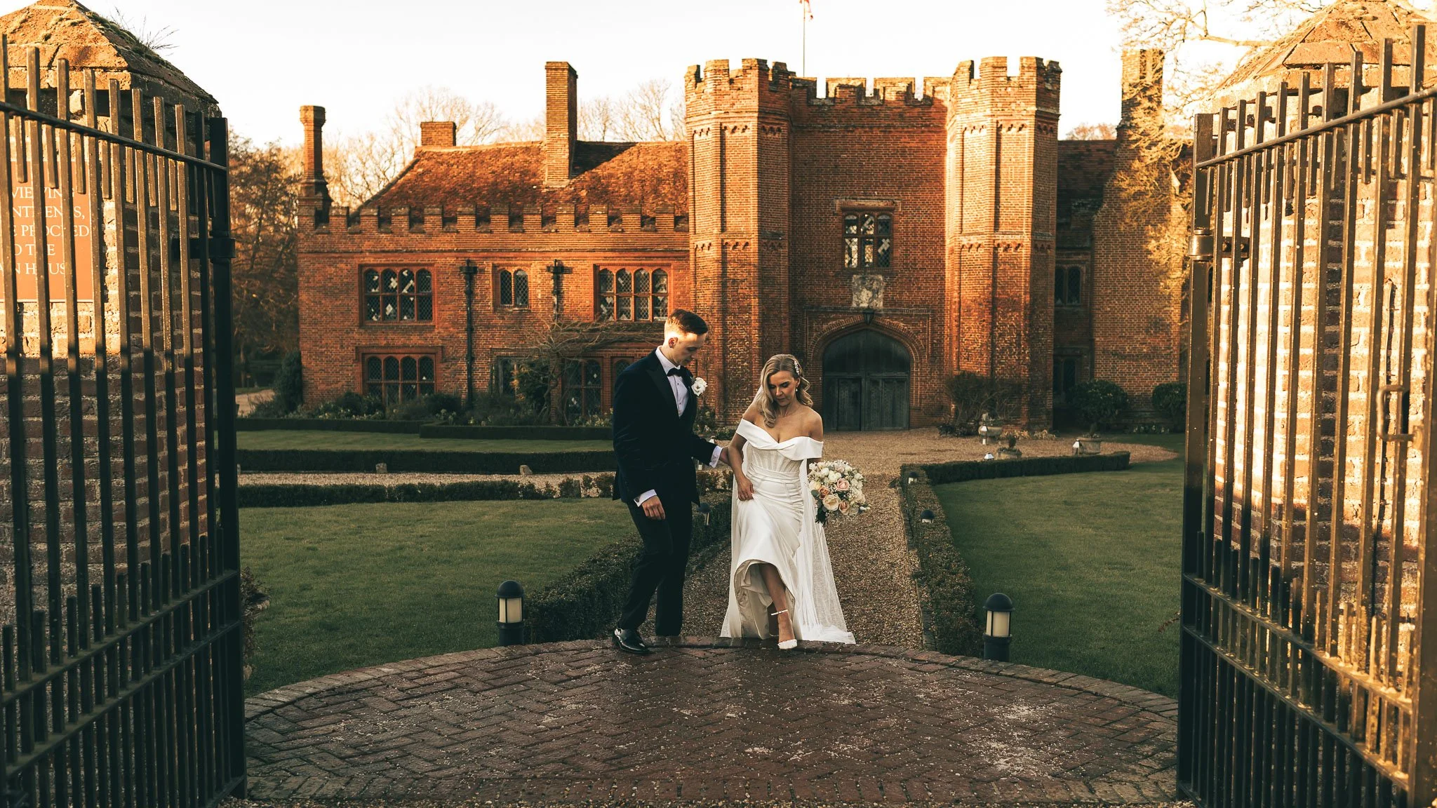 A couple walk together during their black tie winter wedding at Leez Priory in Essex