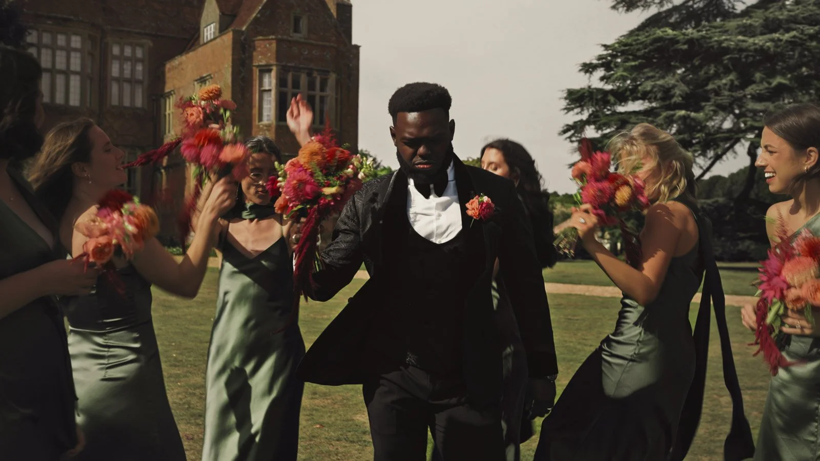 Editorial-style wedding photography from a colourful riverside celebration with bold florals and a marquee reception.