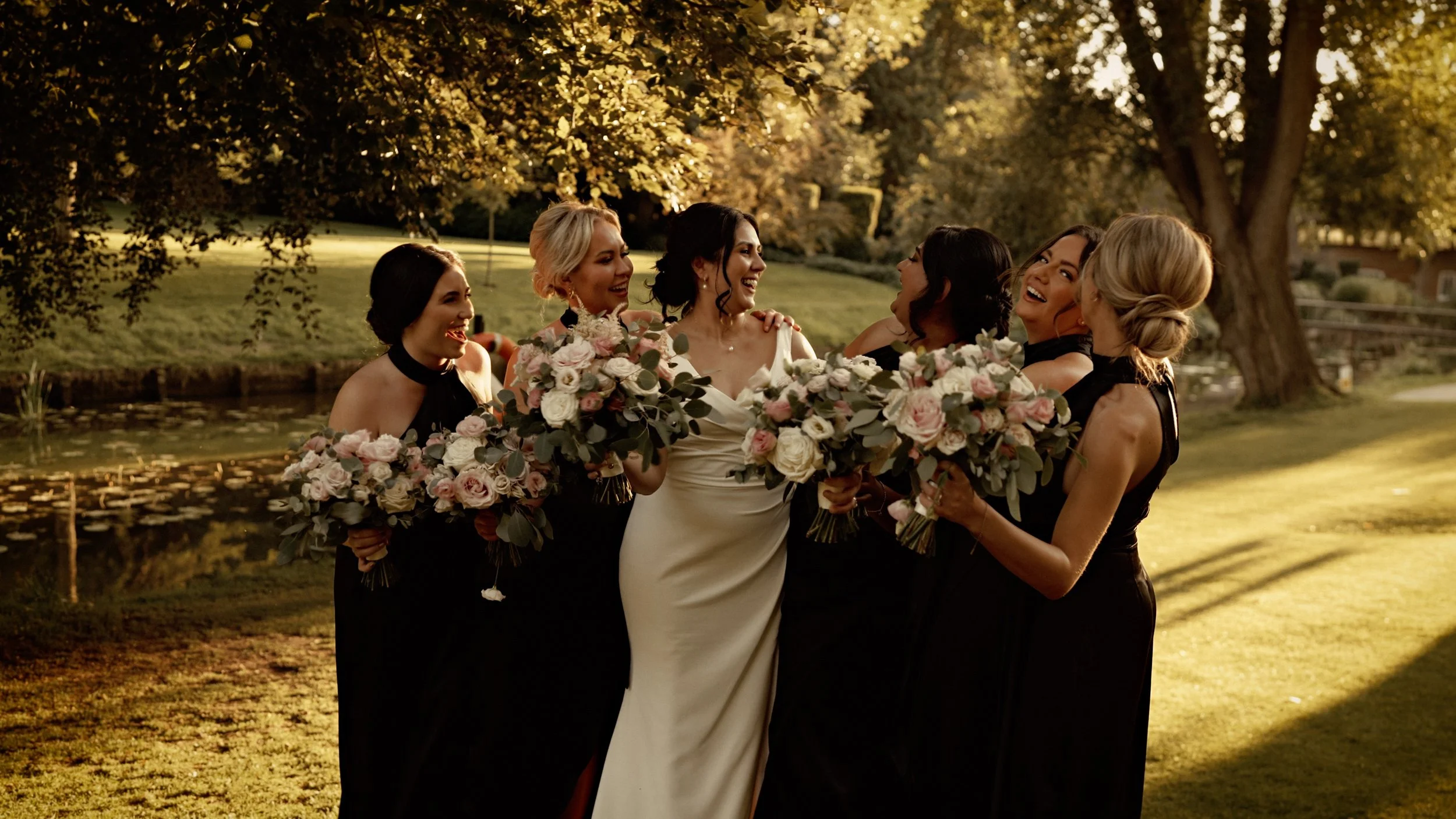 Candid bride and bridesmaid moments by the lake at The Orangery Maidstone during a summer wedding