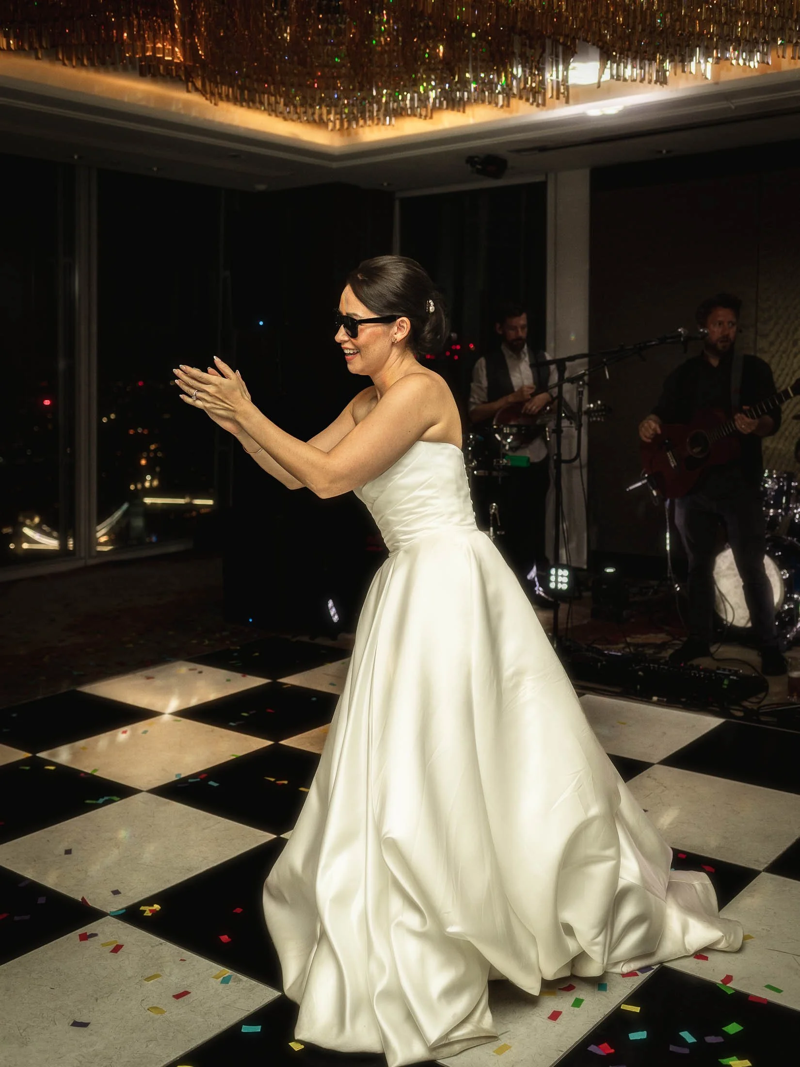 A dance floor portrait from an editorial London wedding showing a bride wearing sunglasses.