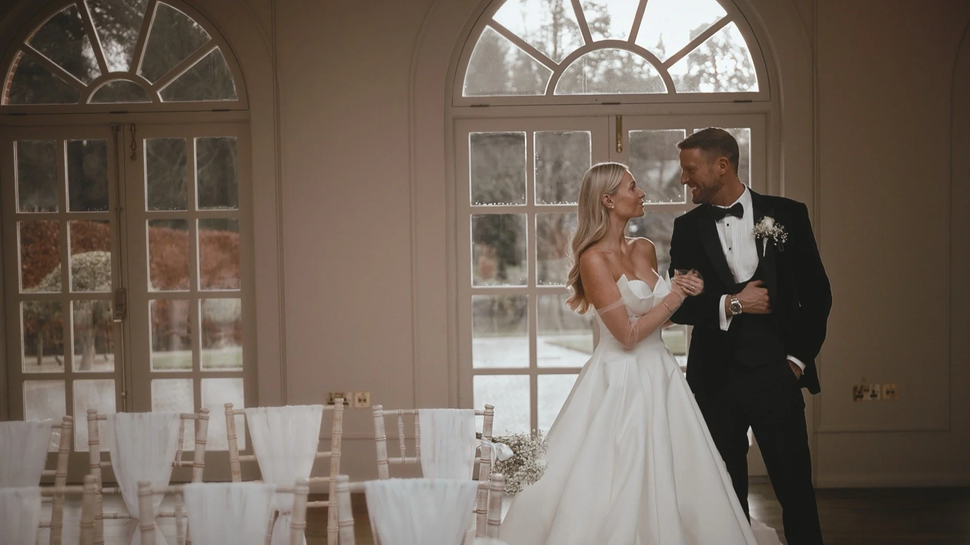 A couple walk together during their black tie New Years Eve wedding at The Orangery in Kent