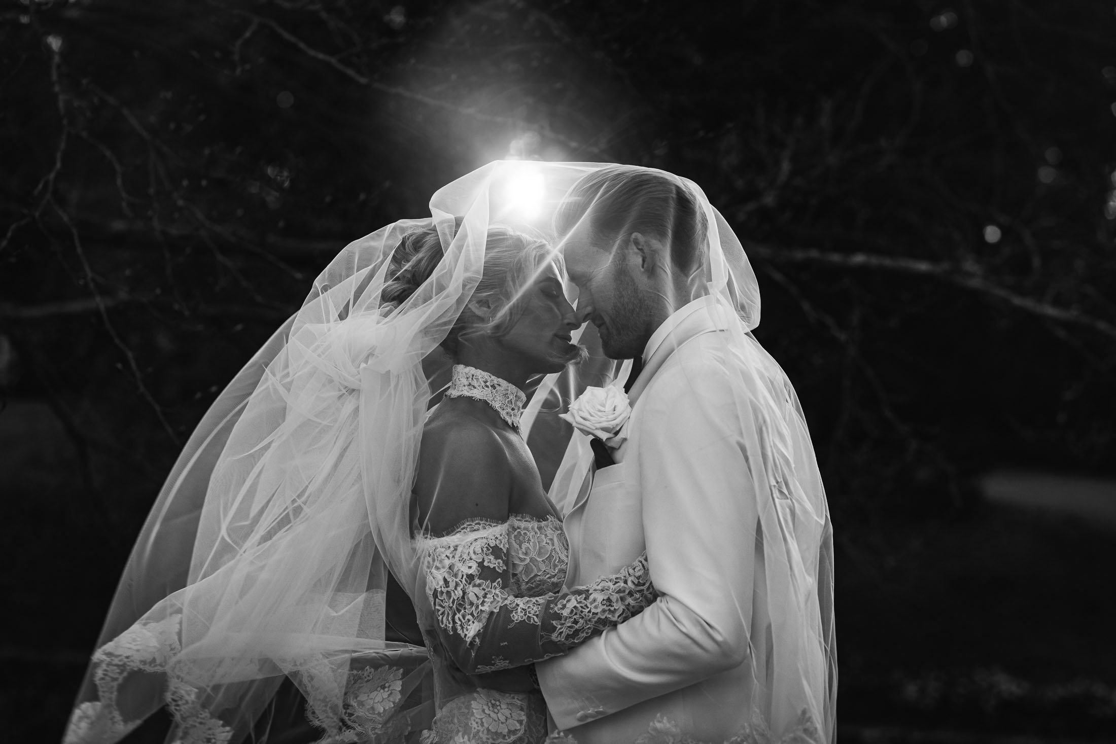 A cinematic wedding videography and photography moment of a couple underneath a veil at sunset during an Orangery Maidstone wedding in Kent.
