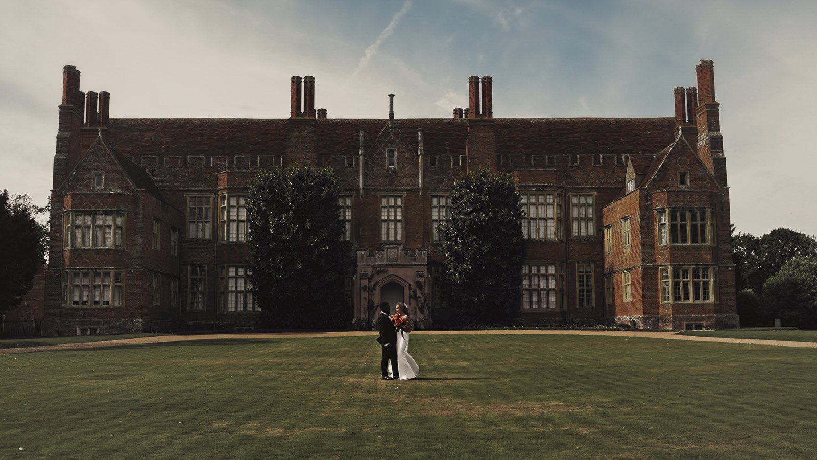 Editorial-style wedding photography from a colourful riverside celebration with bold florals and a marquee reception.