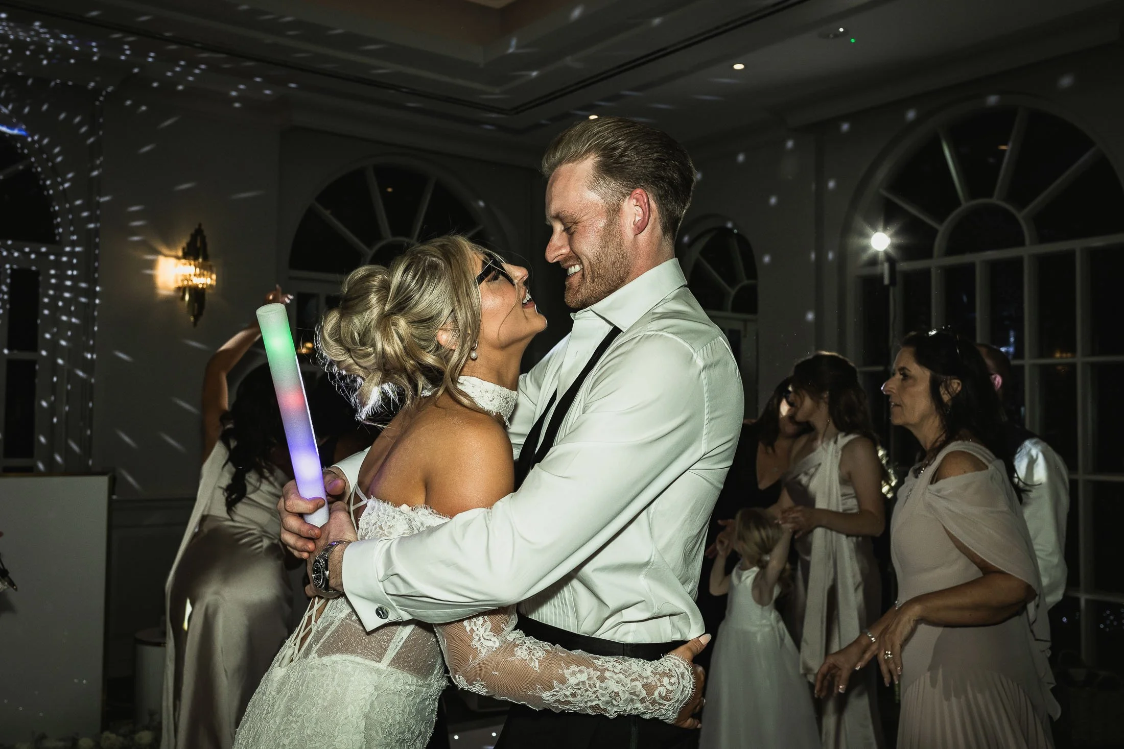 A candid moment as a bride and groom dance together during their black tie wedding day in Kent.