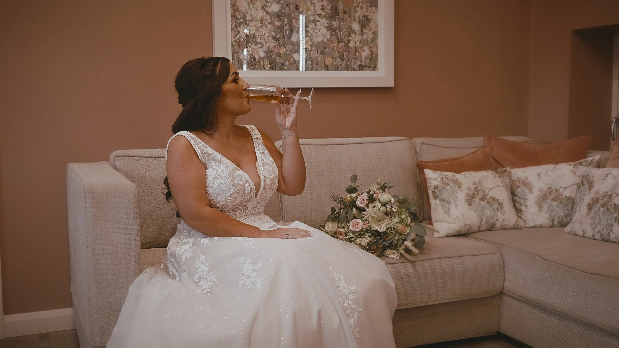 An editorial shot of a bride sipping Champagne in the bridal preparation salon at Winters Barns in Canterbury.