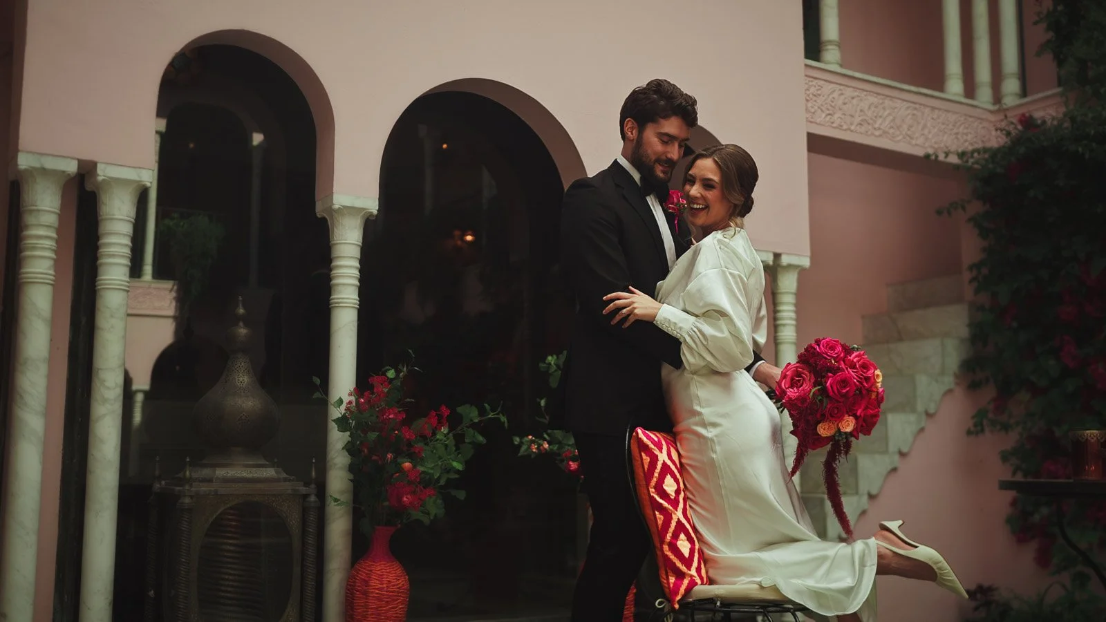 Elegant courtyard portrait framed by archways and saturated florals